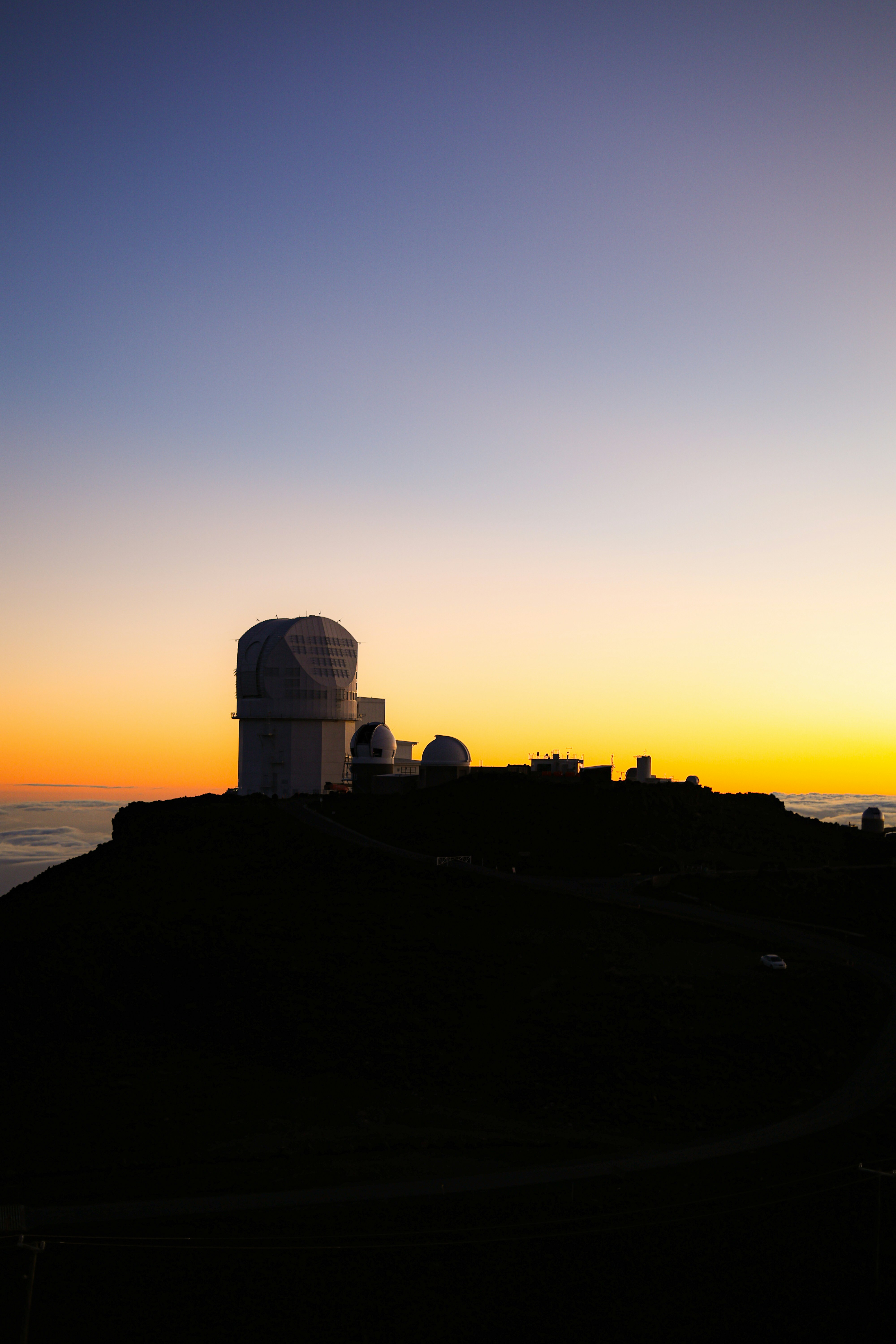 Il sole sta tramontando su una collina con una torre radio