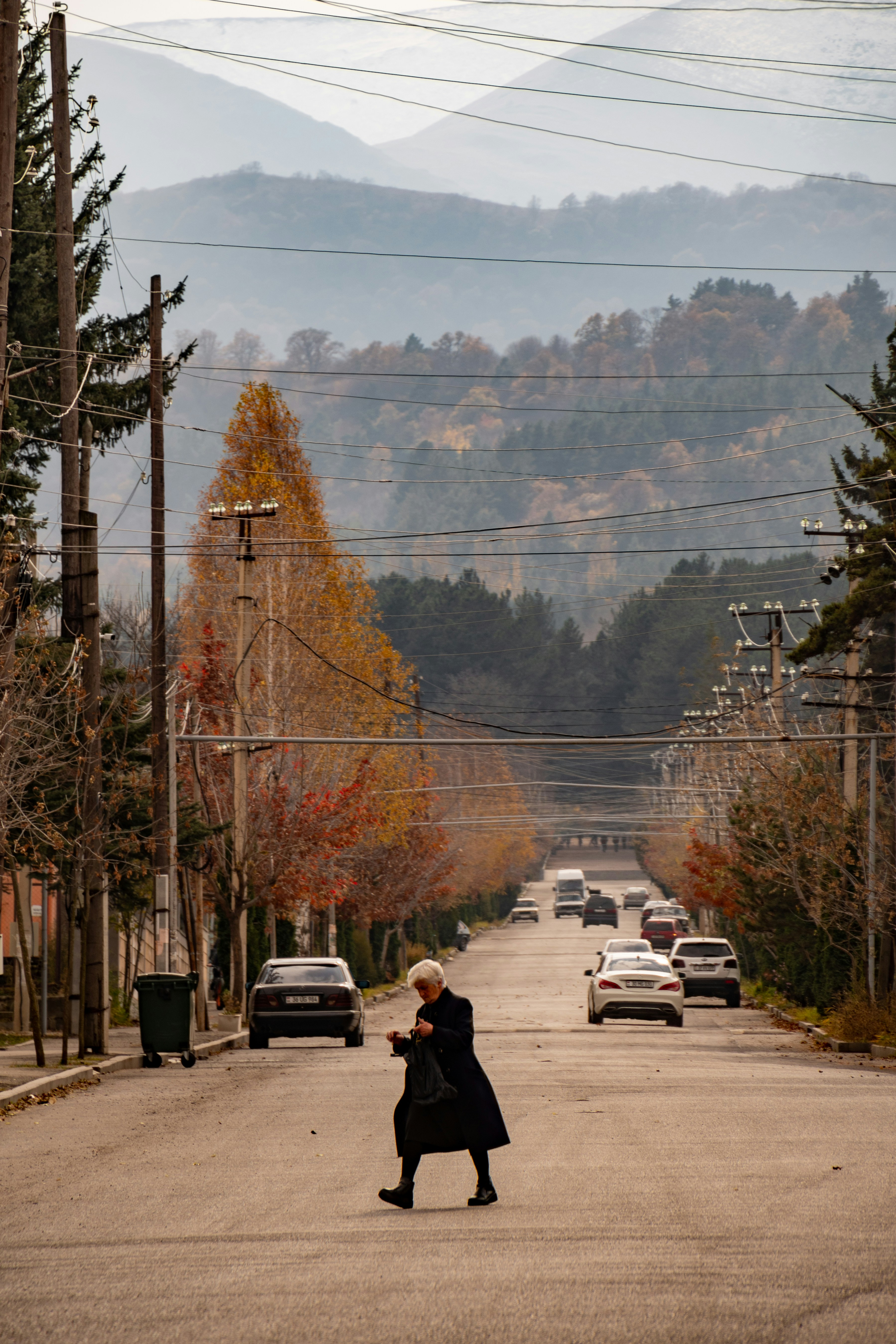 A woman walking down the middle of a street