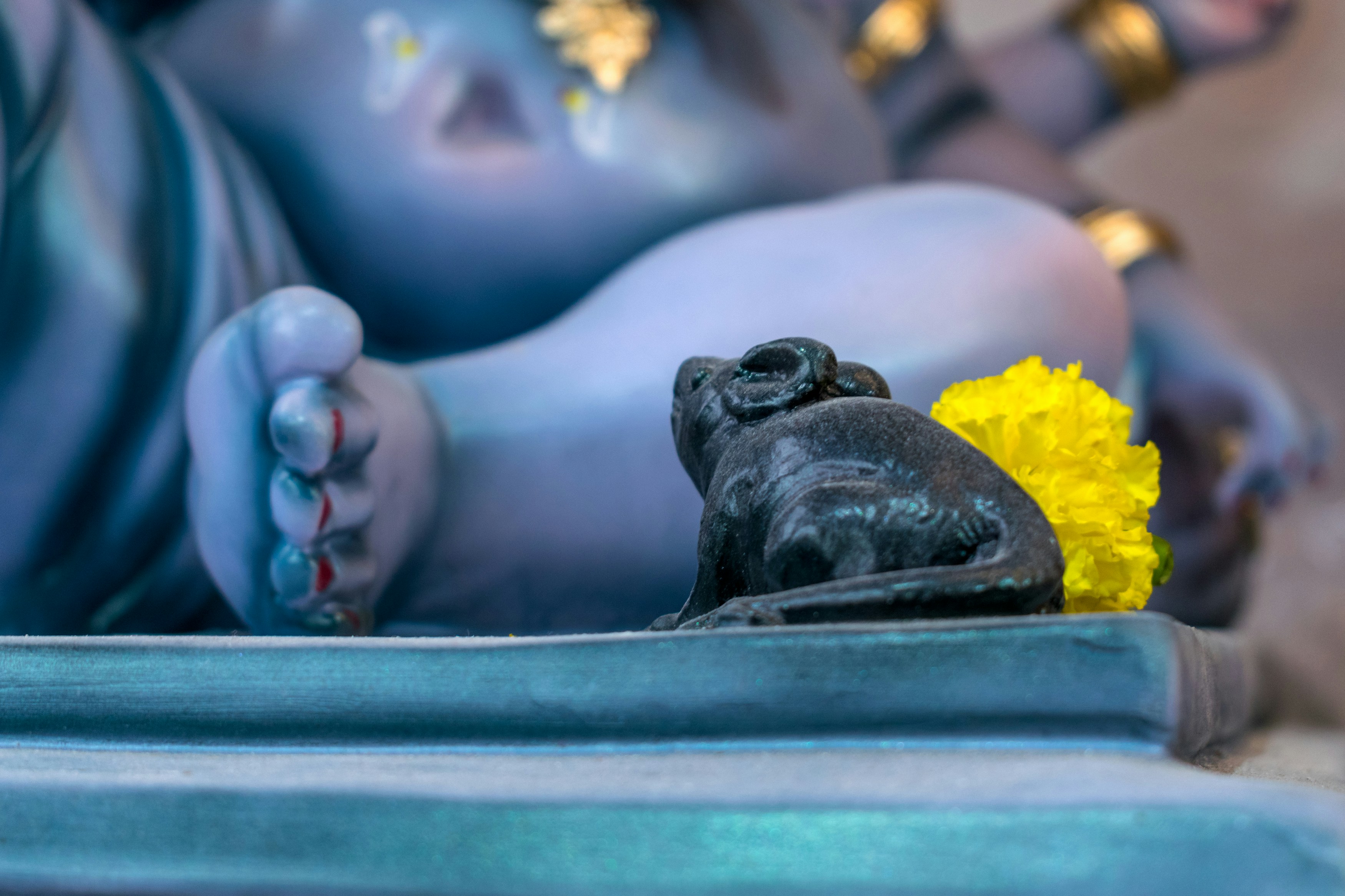 Eine Statue eines Babys, das sich mit einer gelben Blume hinlegt