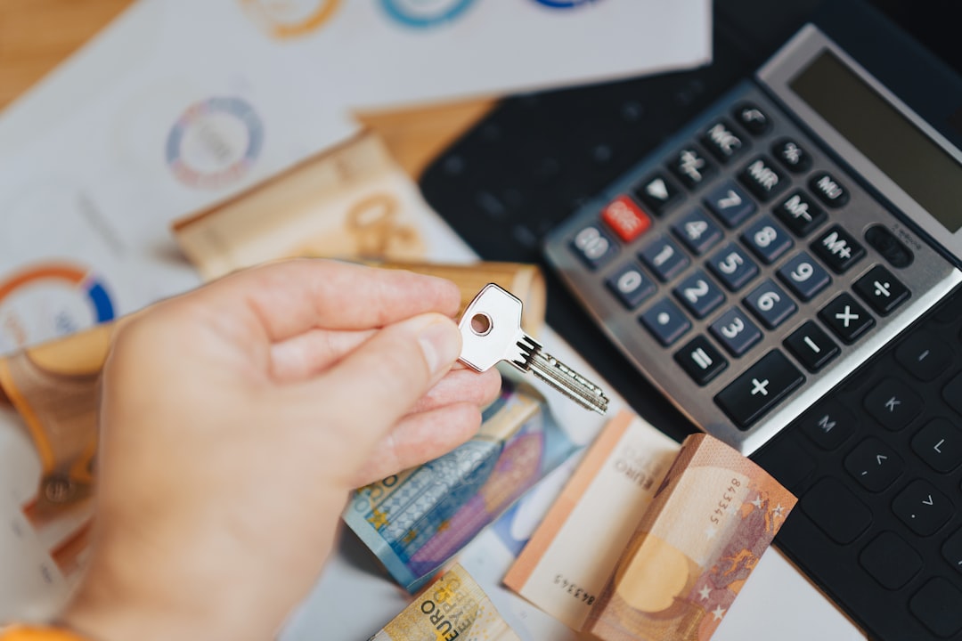 A person is putting money in front of a calculator, Hand holding door key new home money banknotes on documents real estate market calculator