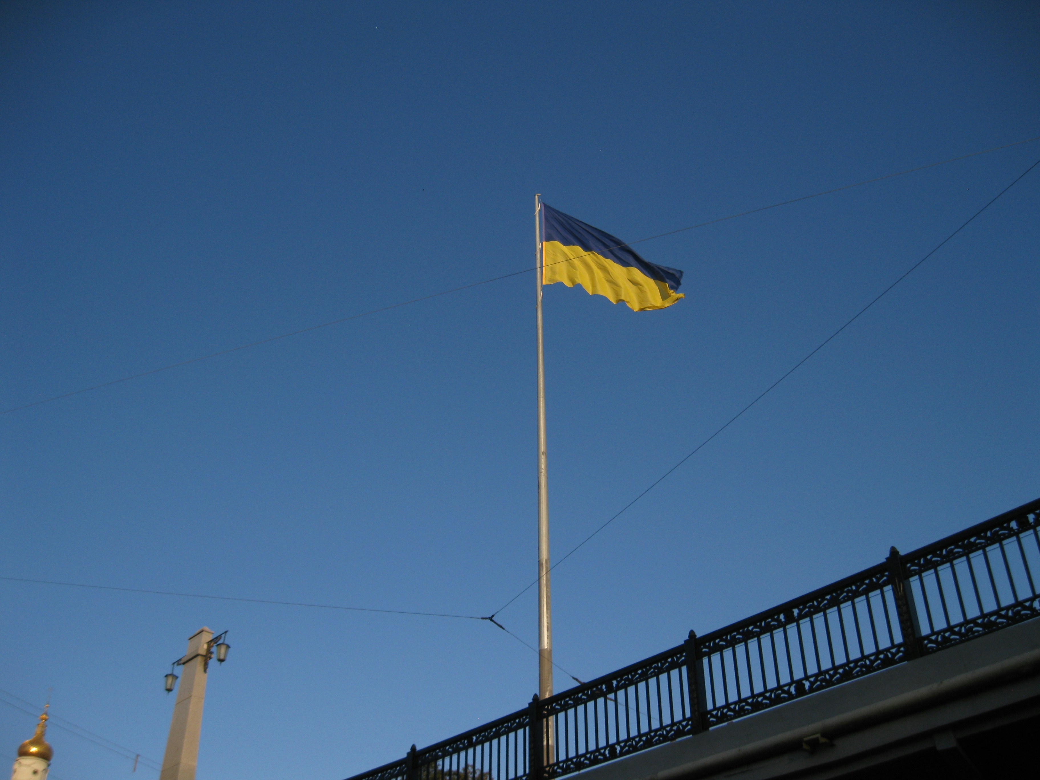 A flag on a pole in front of a bridge