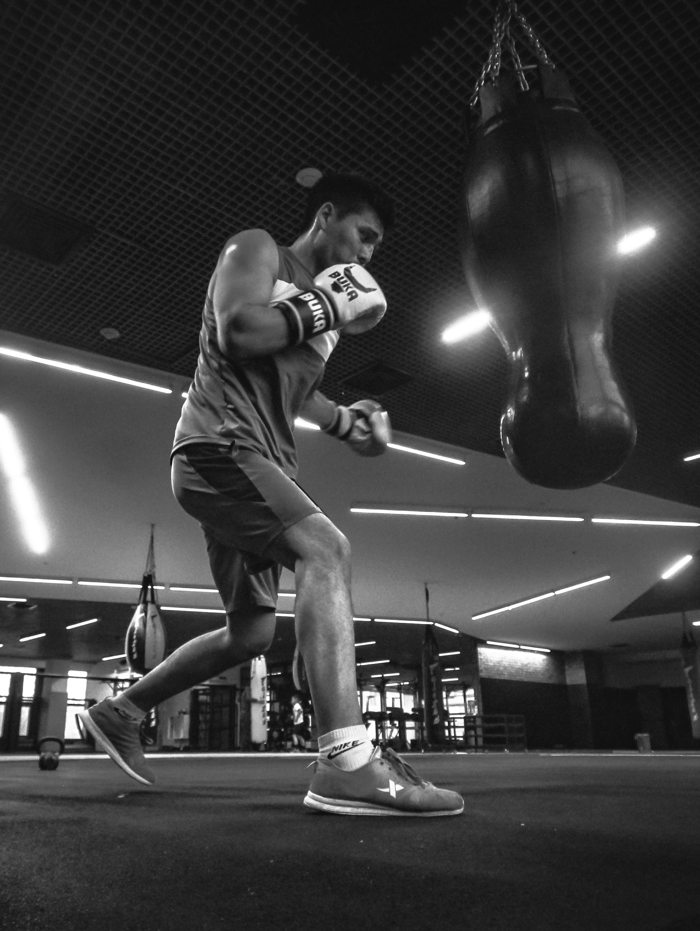 A man standing in a gym with a punching bag