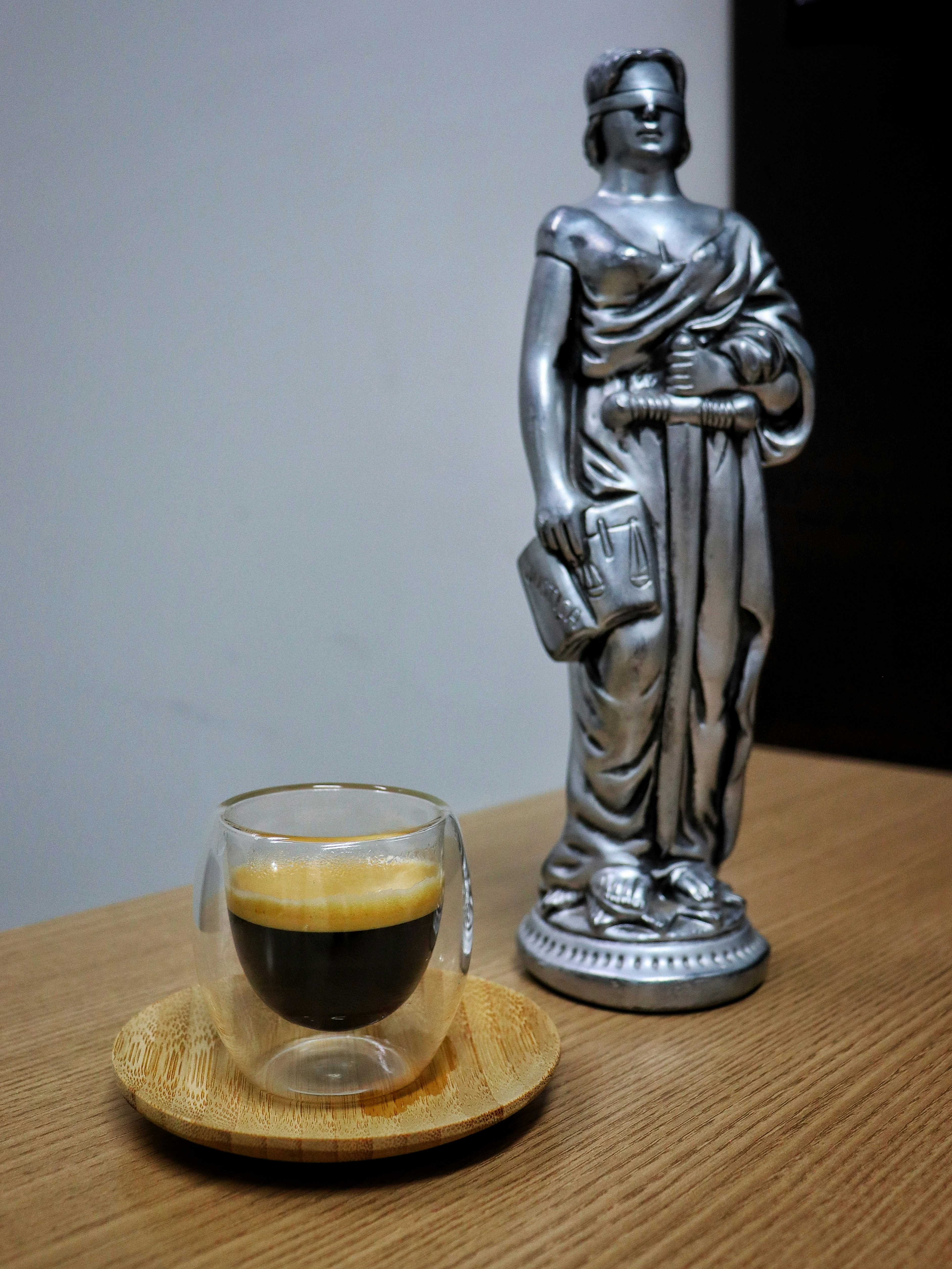 A cup of coffee and a statue on a table