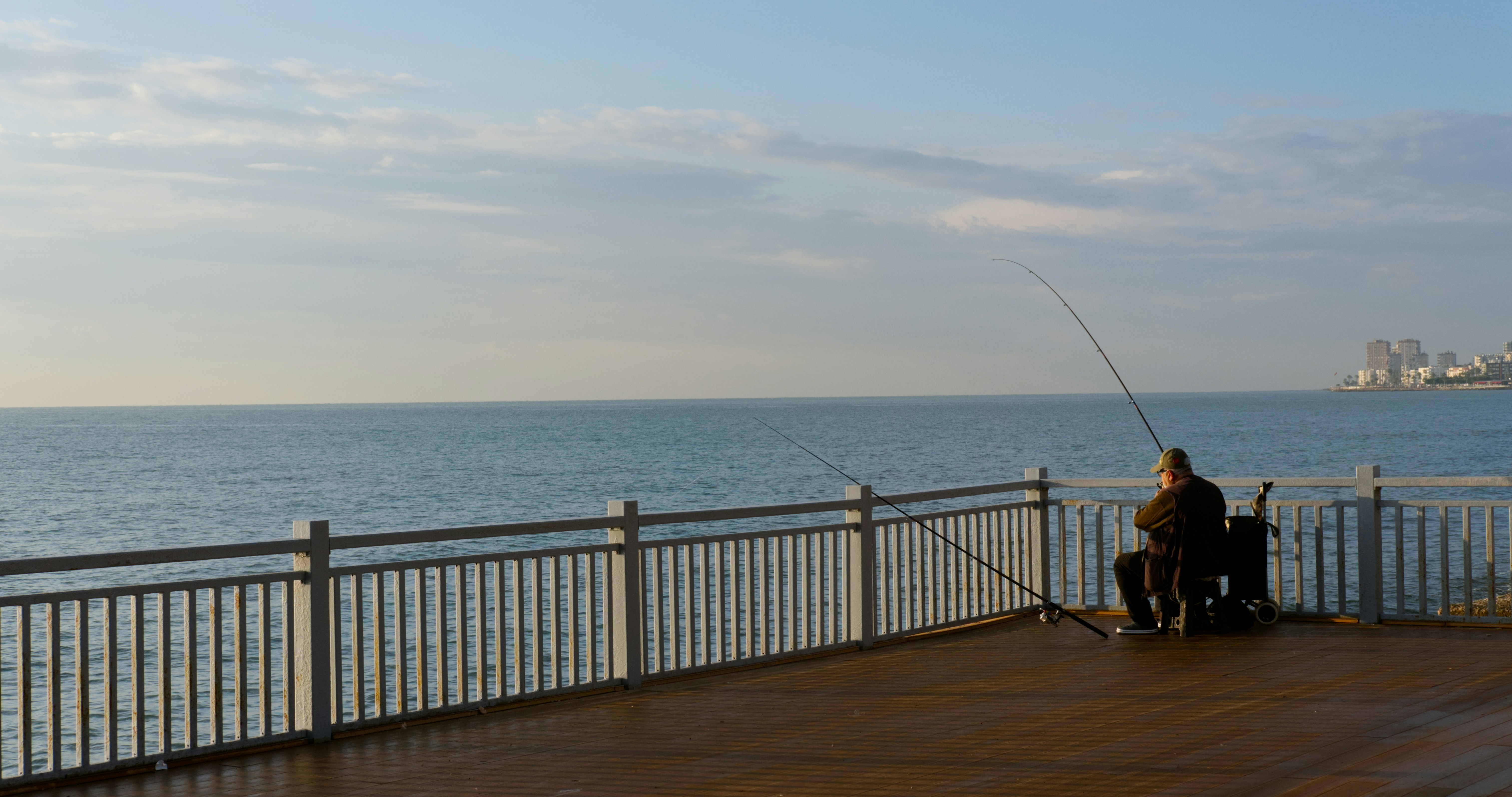 A man sitting on a bench next to the ocean