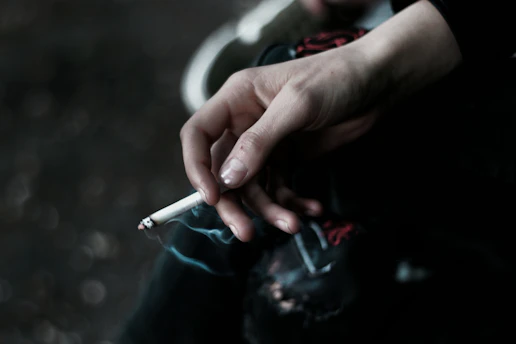 A person holding a cigarette in their hand