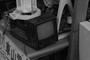 A black and white photo of an old TV and a lamp