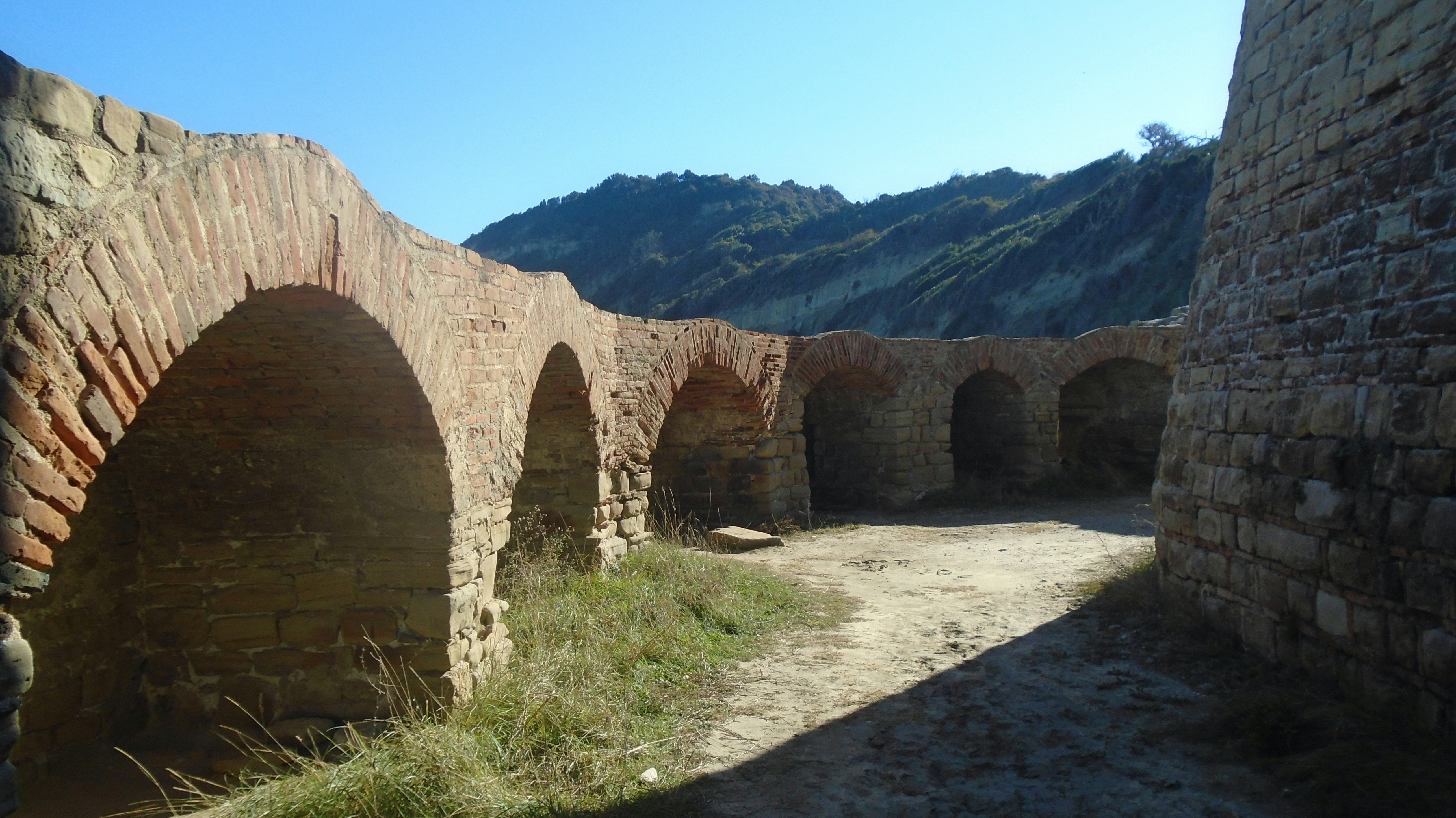 A man is standing on a stone bridge