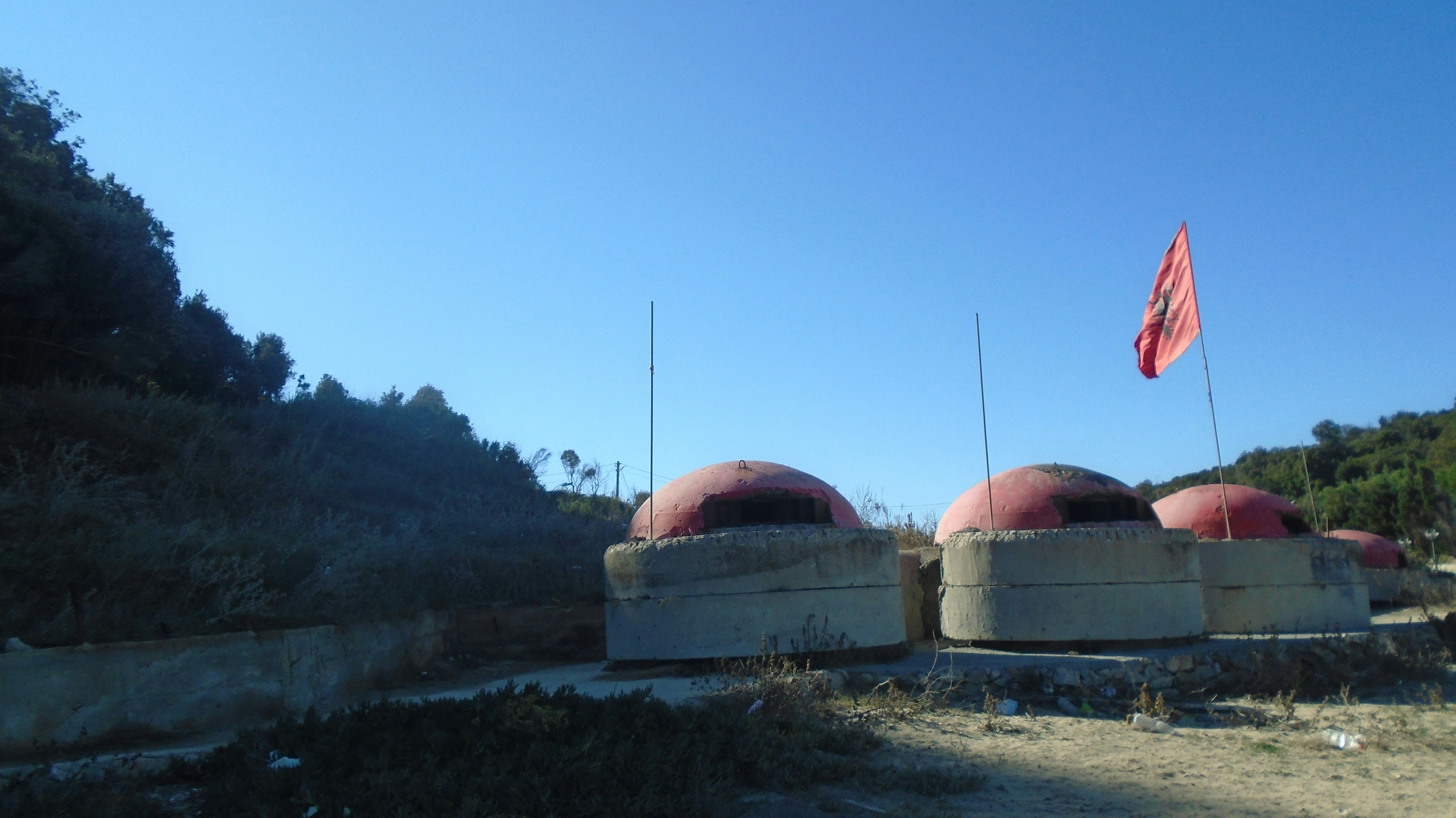 A group of concrete structures sitting on top of a dirt field