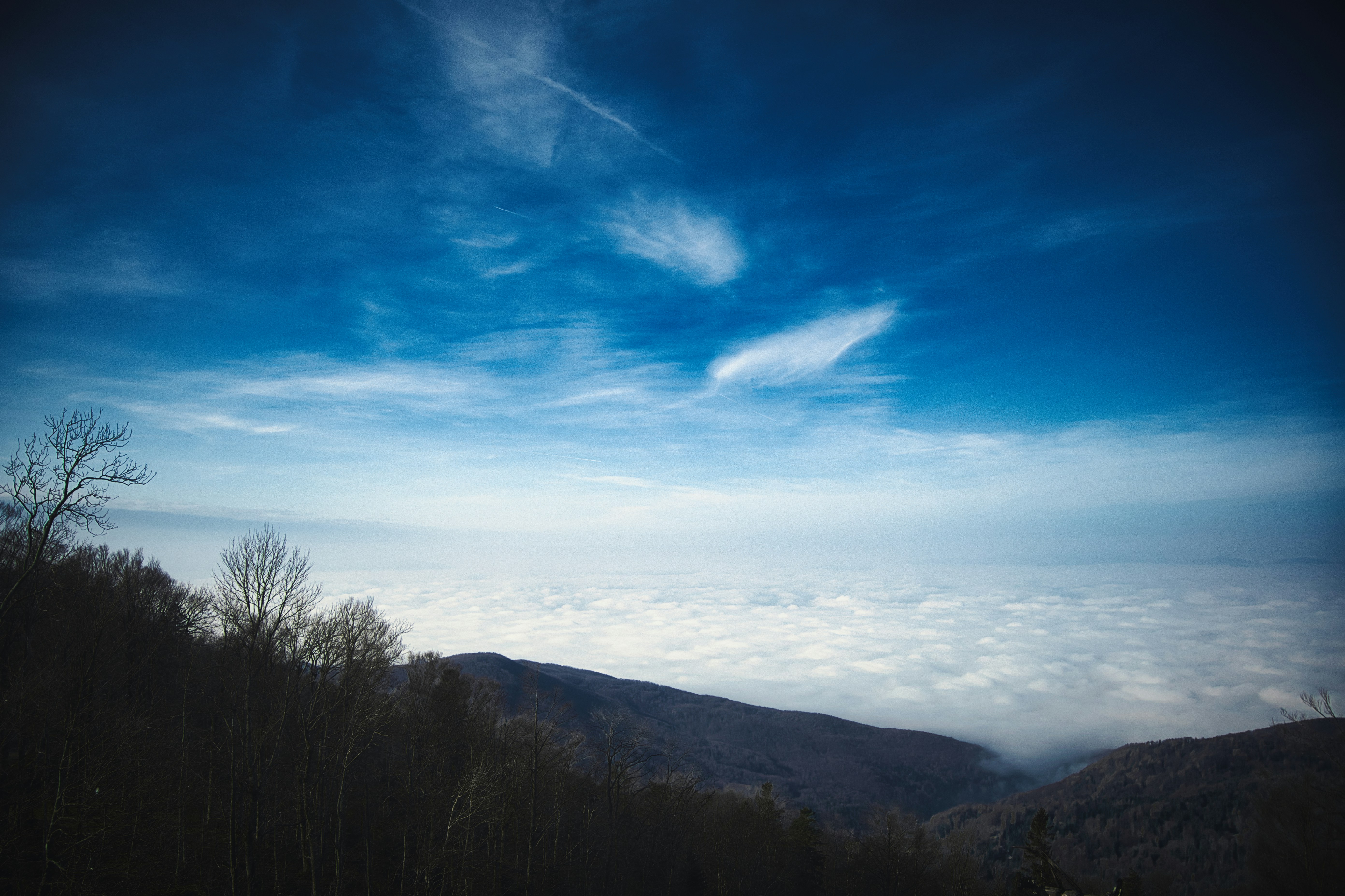 A view of a blue sky and clouds from the top of a mountain