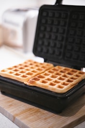 A waffle sitting on top of a wooden cutting board