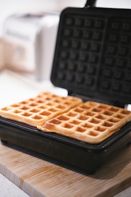 A waffle sitting on top of a wooden cutting board