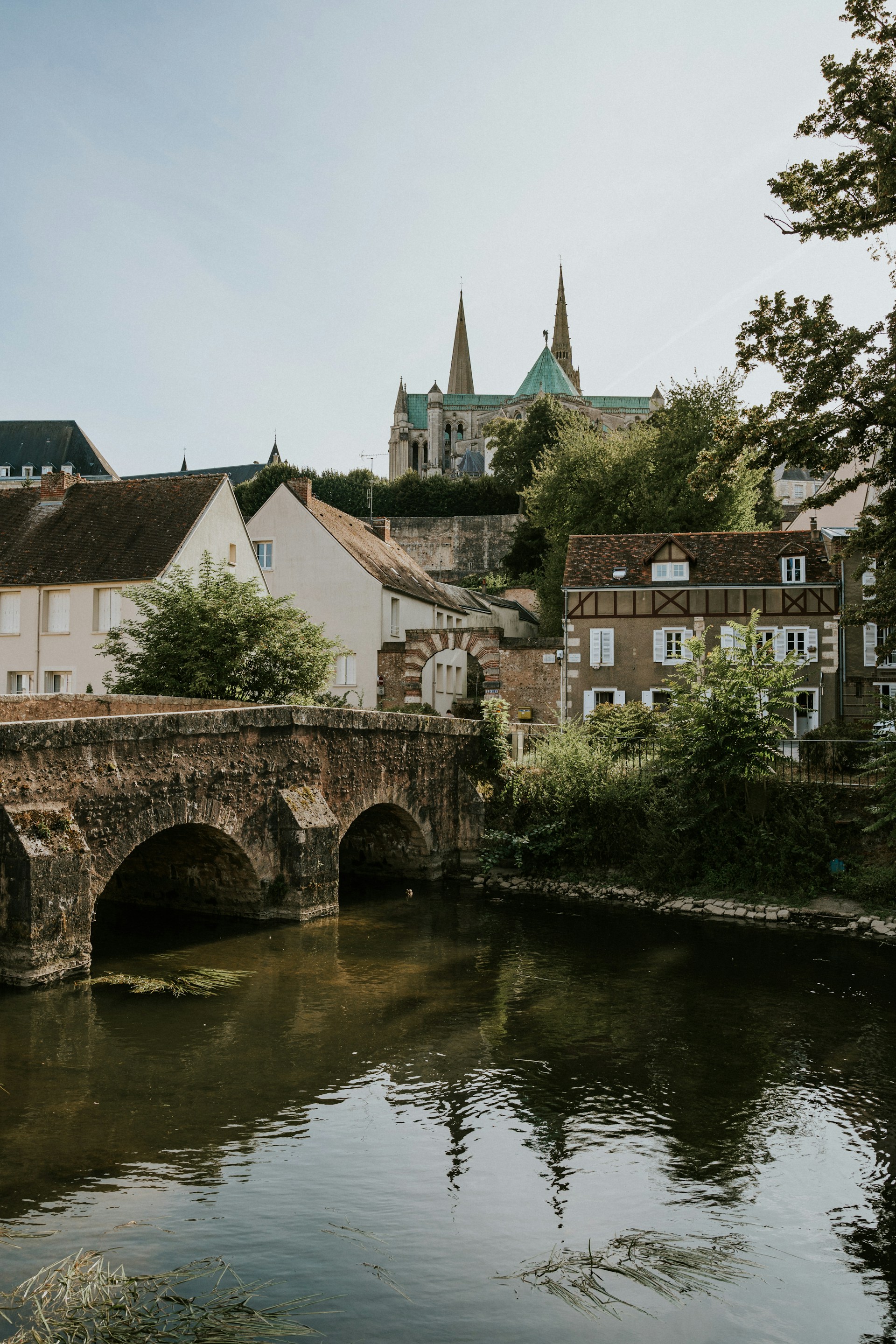 A bridge over a river with buildings in the background
