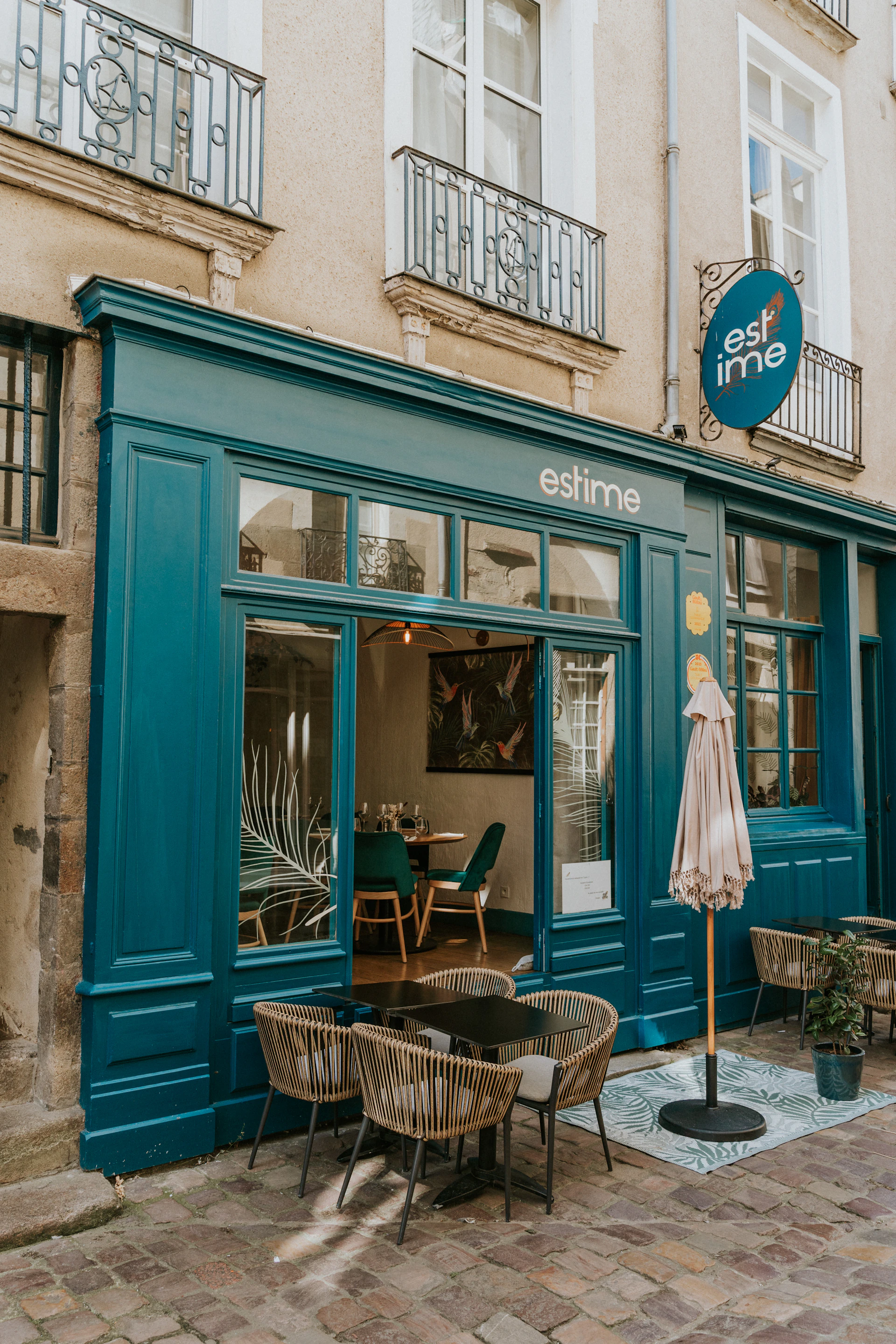 The outside of a restaurant with tables and chairs