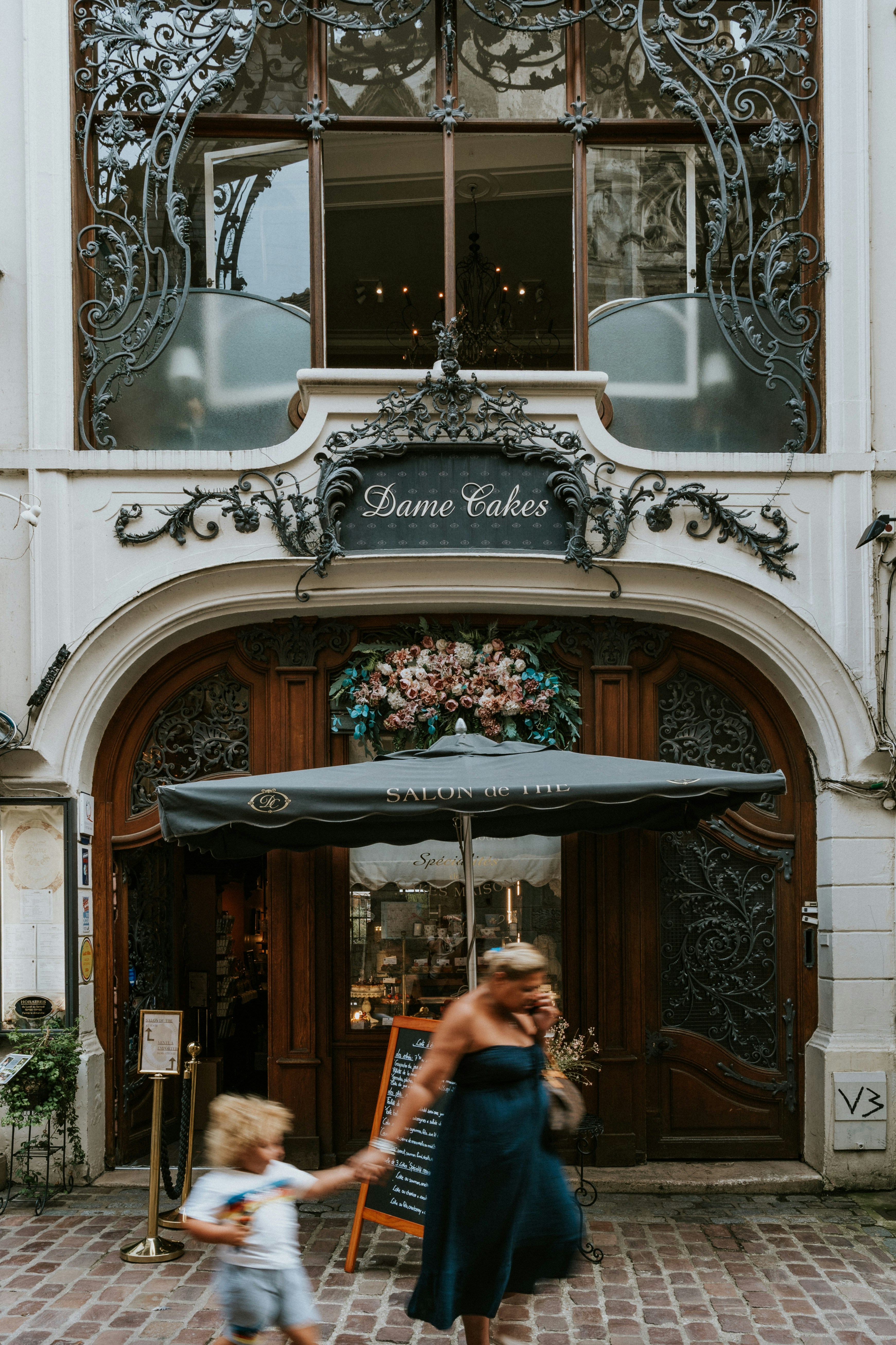 Une femme et un enfant marchant devant un immeuble