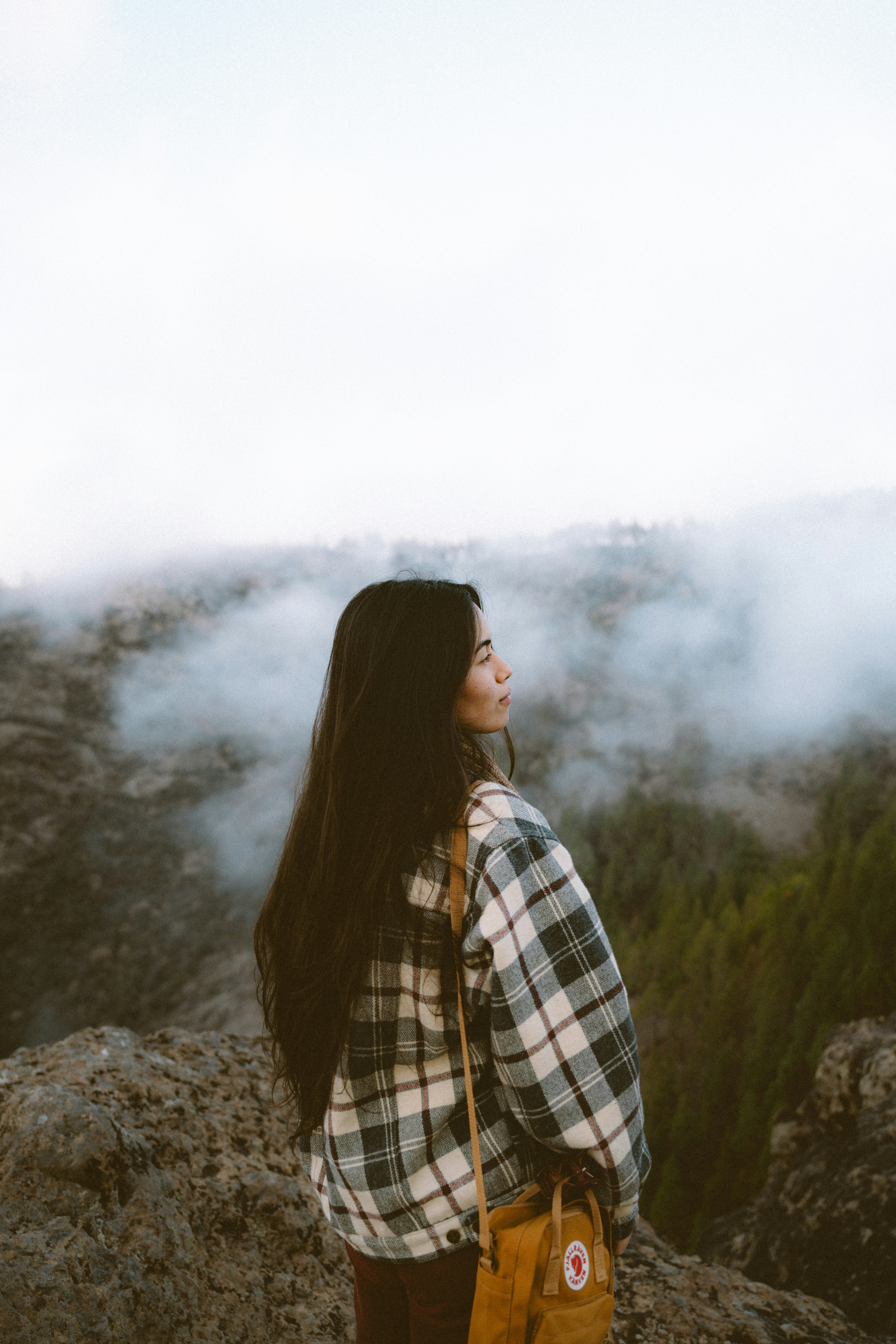 A woman standing on top of a mountain