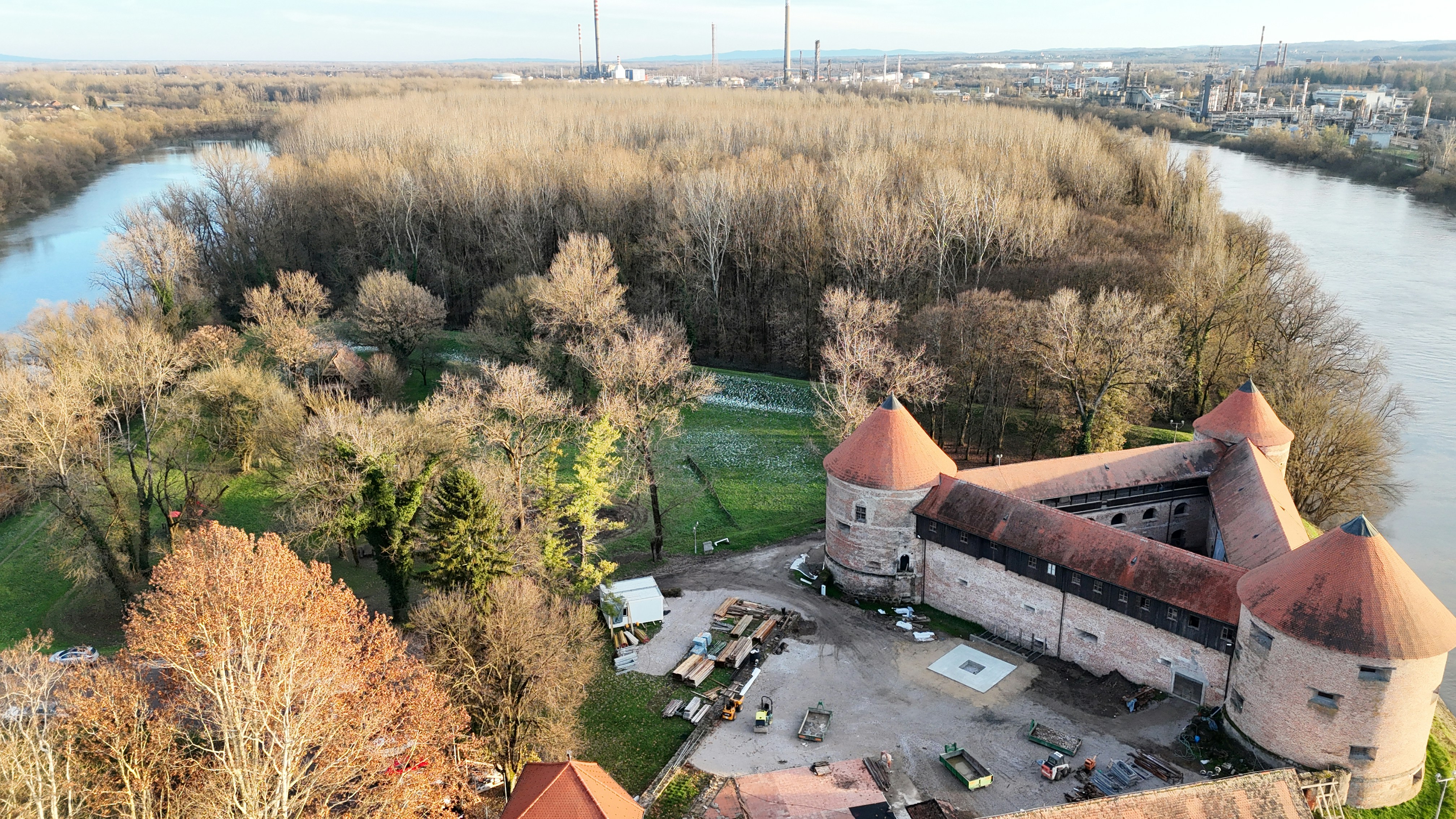 An aerial view of a castle with a river in the background