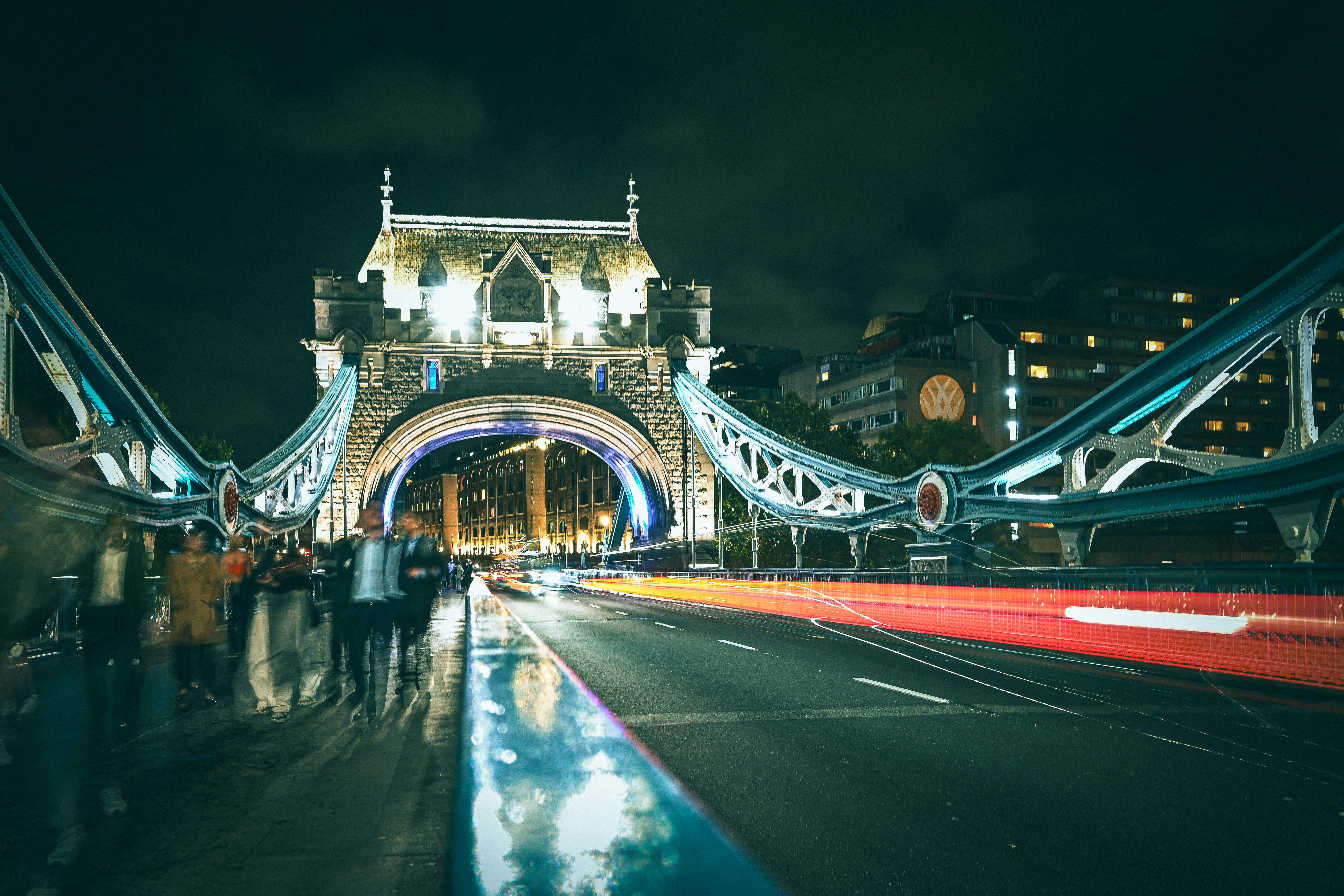 A group of people standing on the side of a bridge