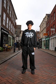 A young man standing on a brick street