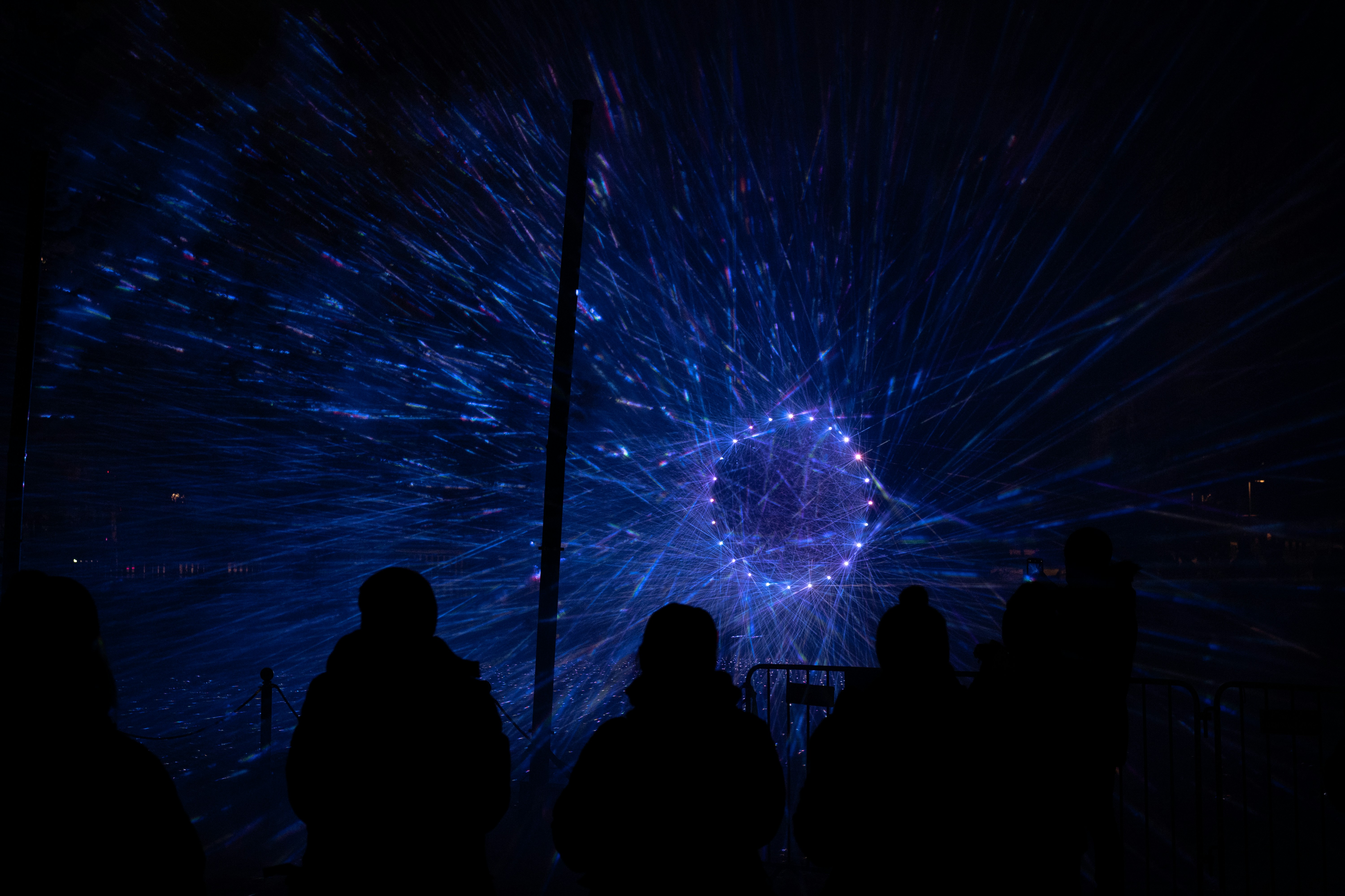 A group of people standing in front of a fireworks display