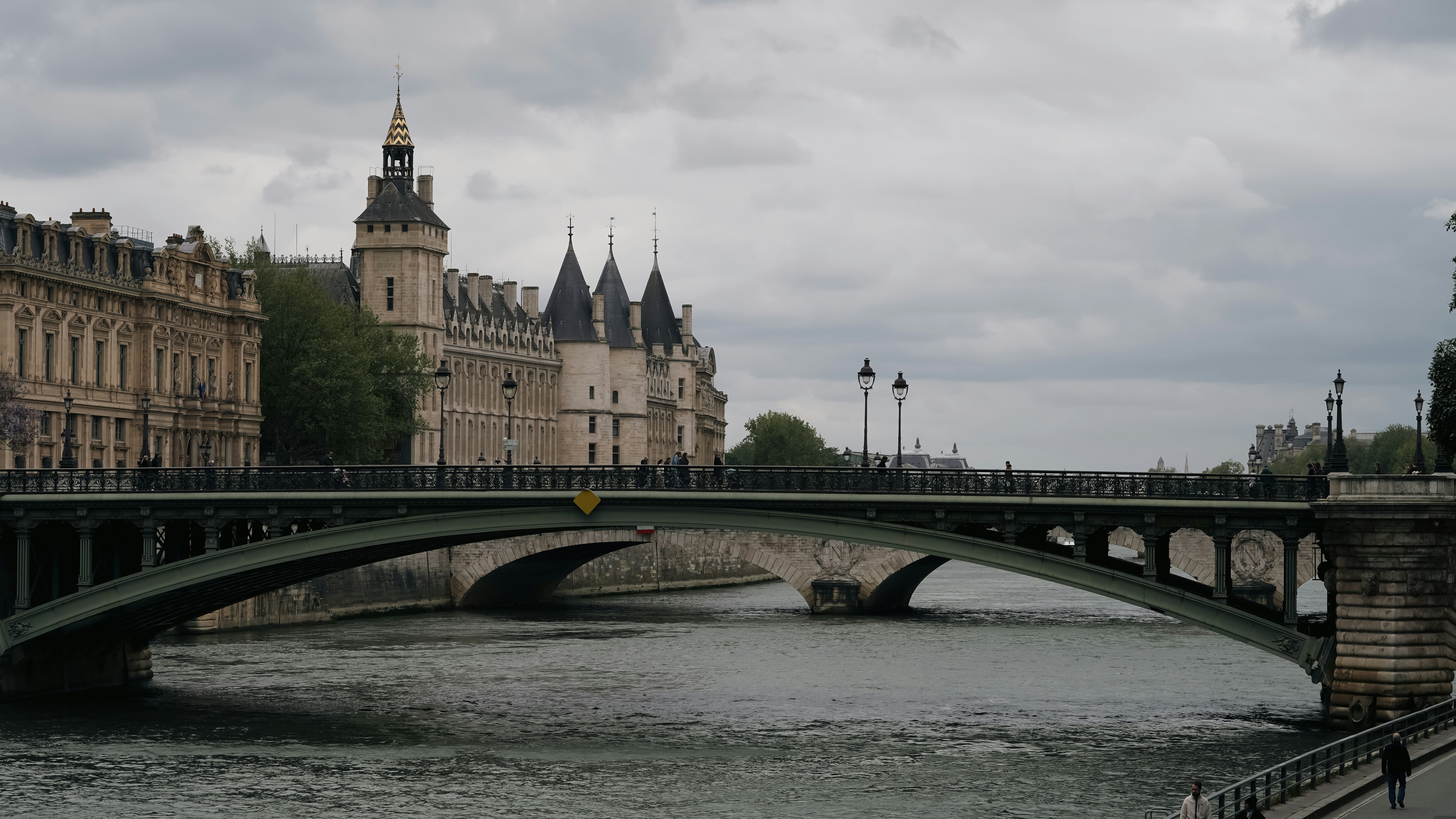 Uma ponte sobre um rio com um castelo ao fundo