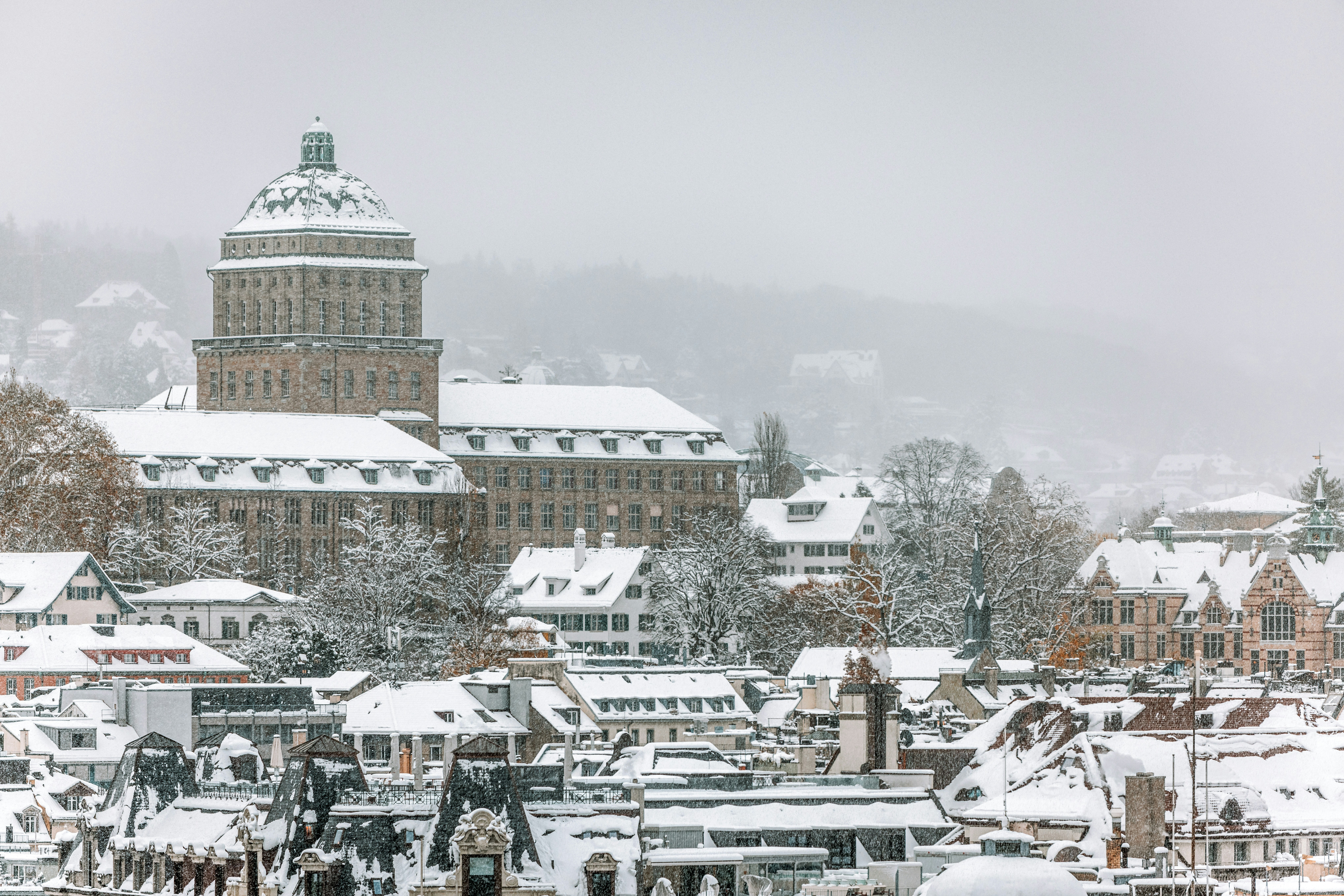 A snowy city with a clock tower in the background