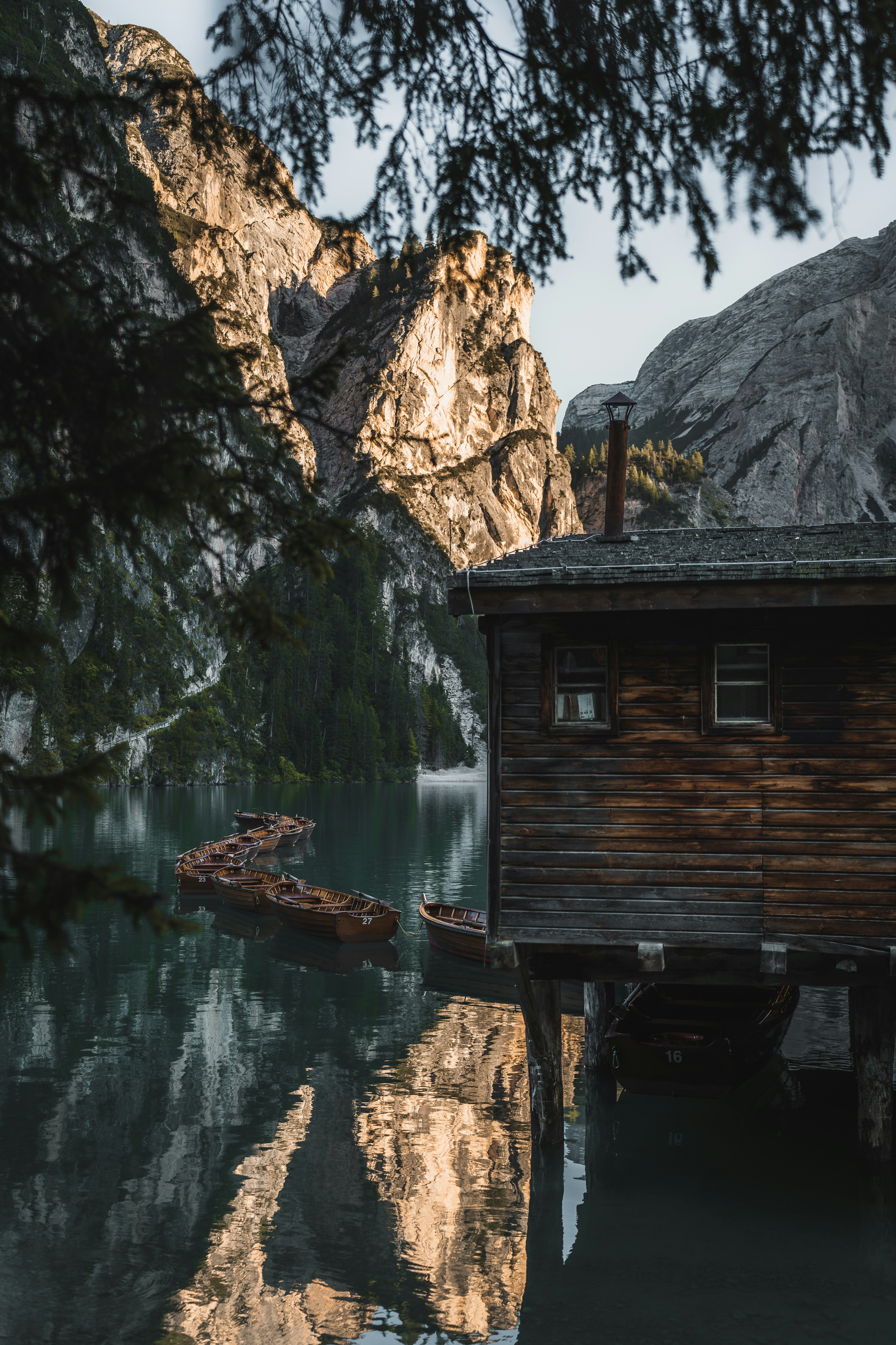 A small cabin sitting on top of a lake next to a mountain
