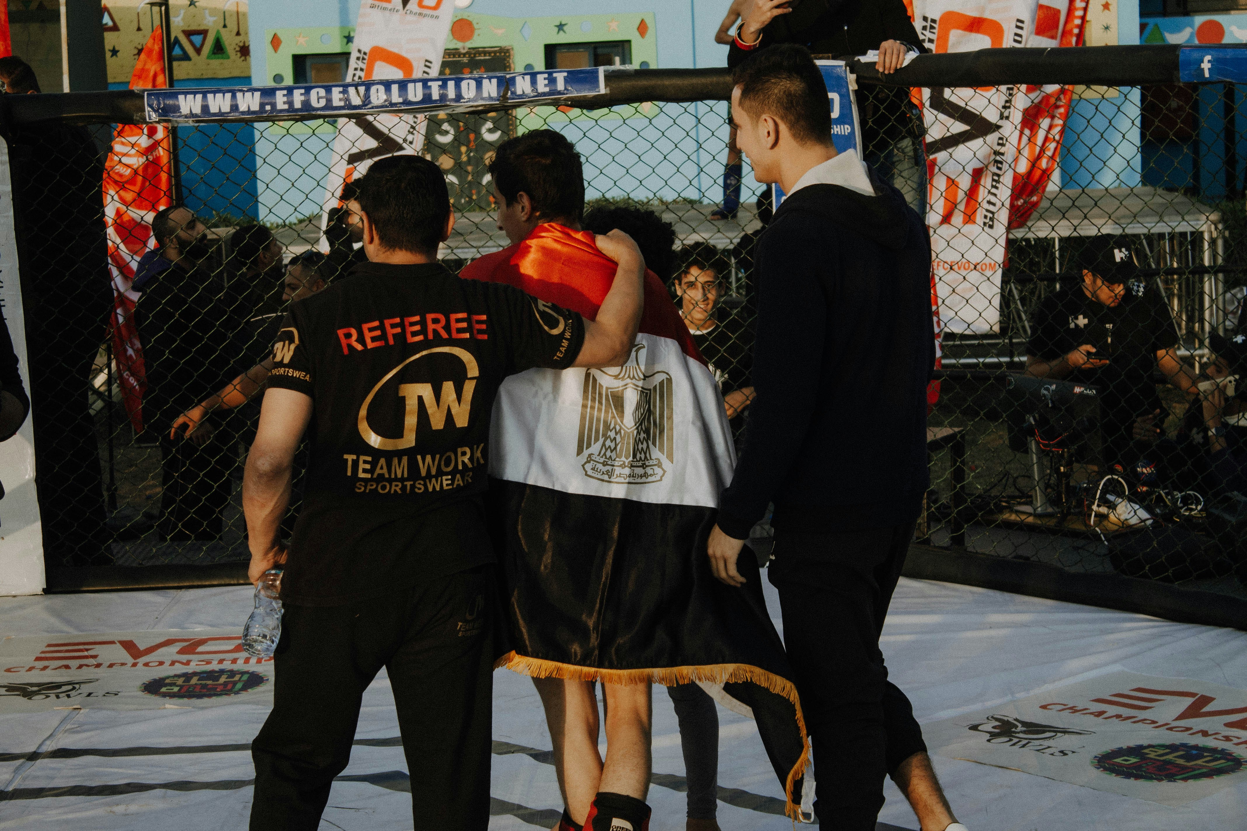 A group of men standing around a man sitting on a chair