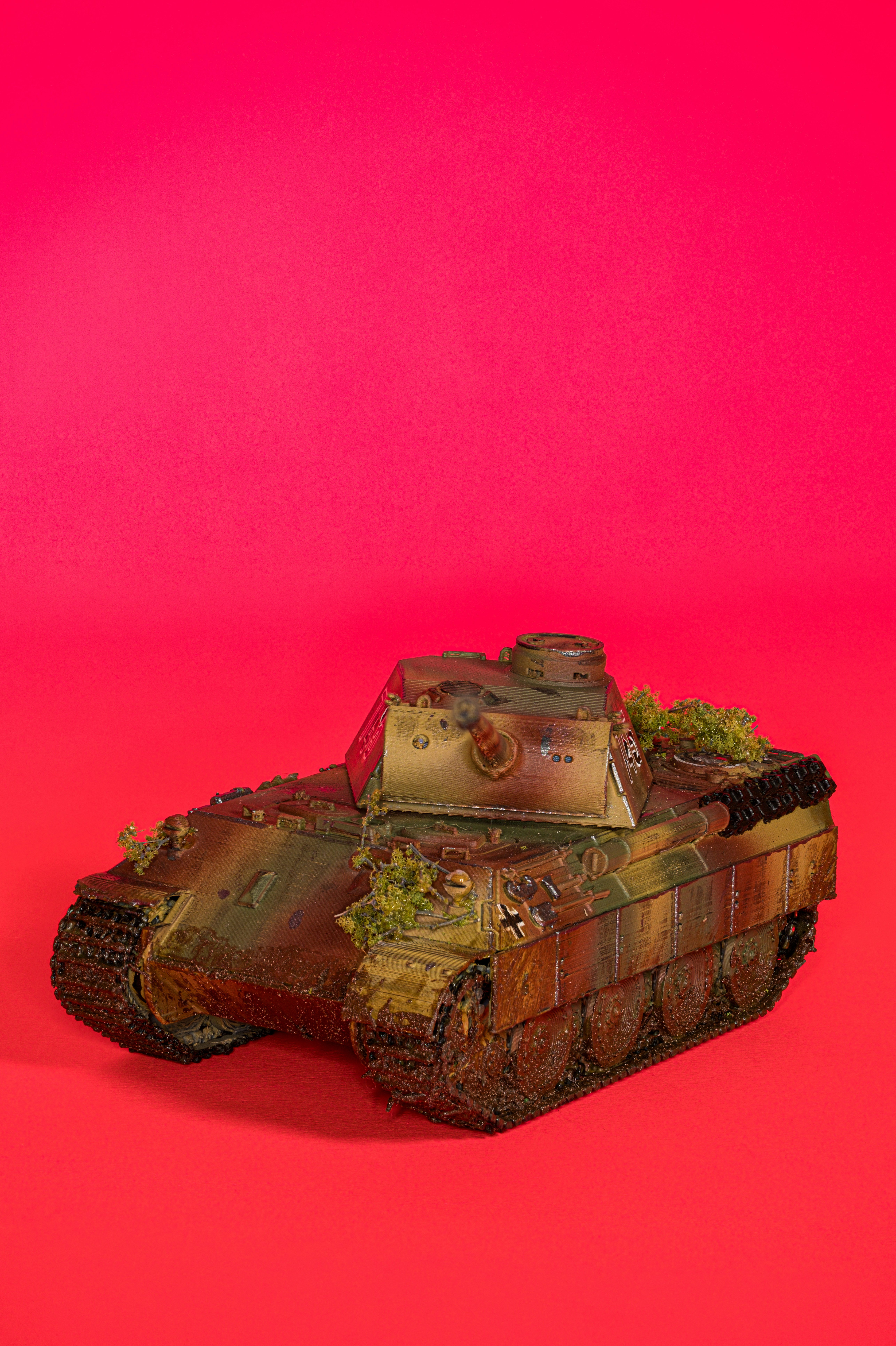 A toy tank sitting on top of a red surface
