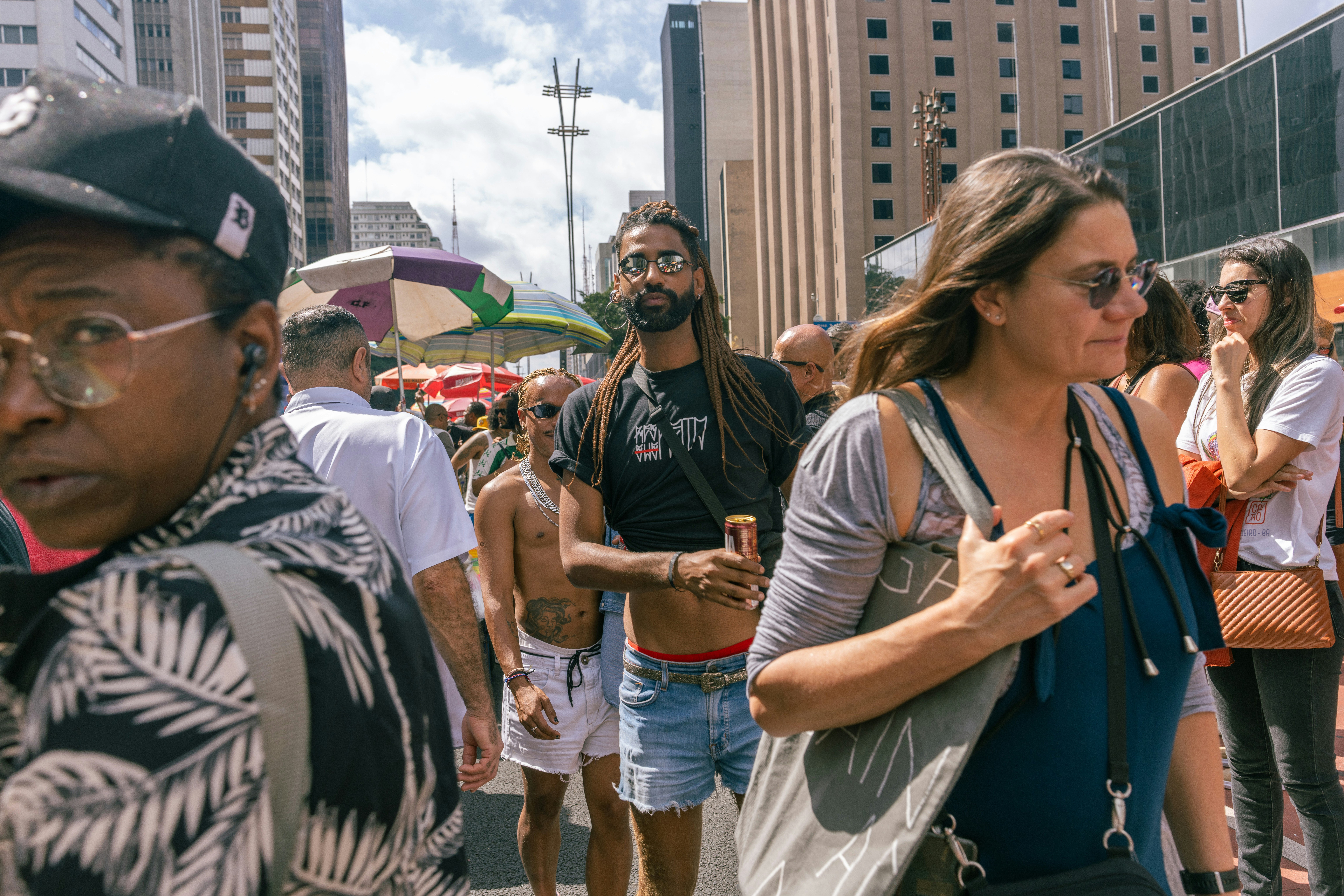 A group of people walking down a street next to tall buildings