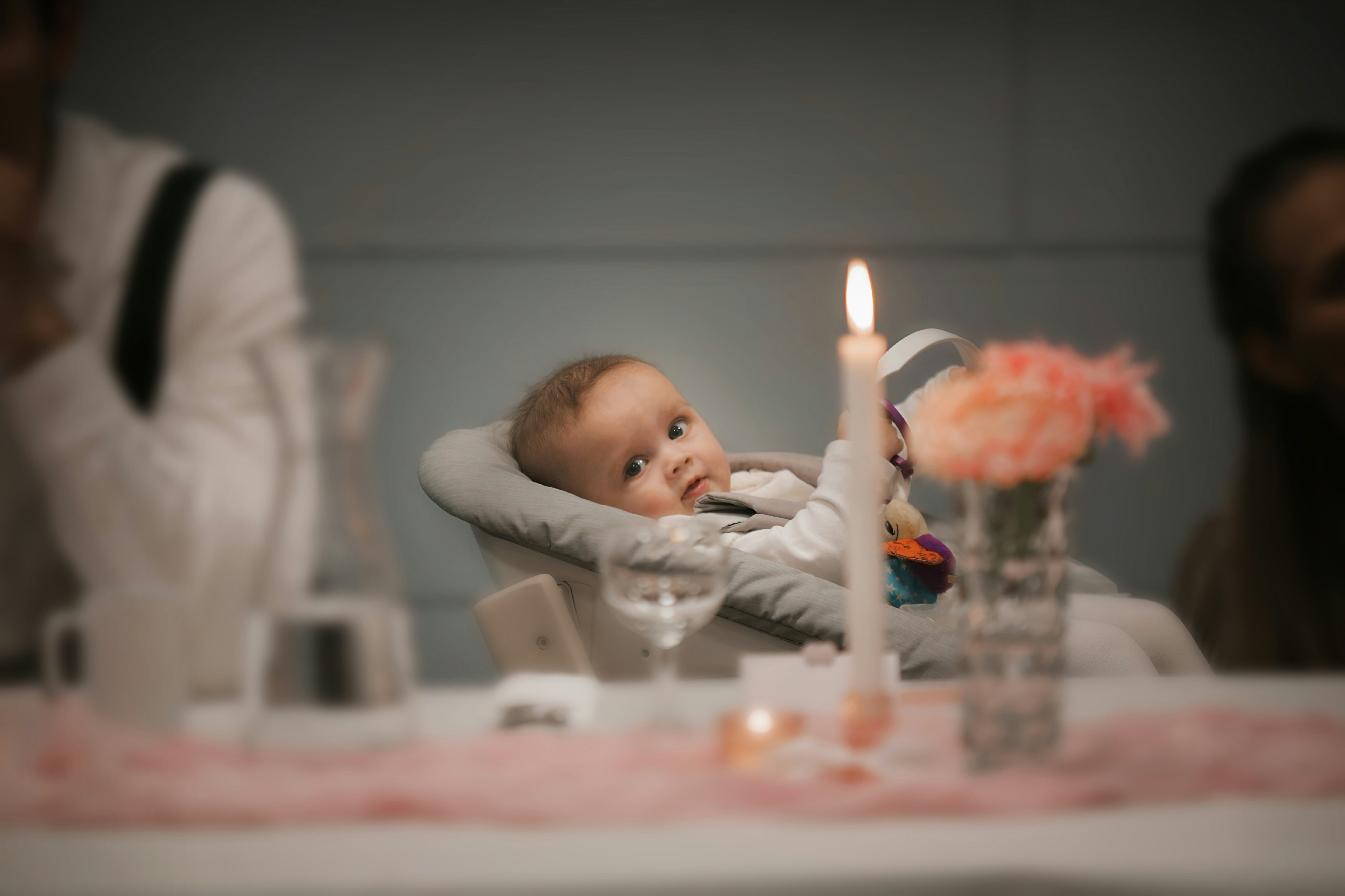 A baby sitting in a high chair at a table