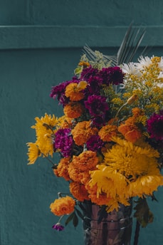 A vase filled with lots of different colored flowers
