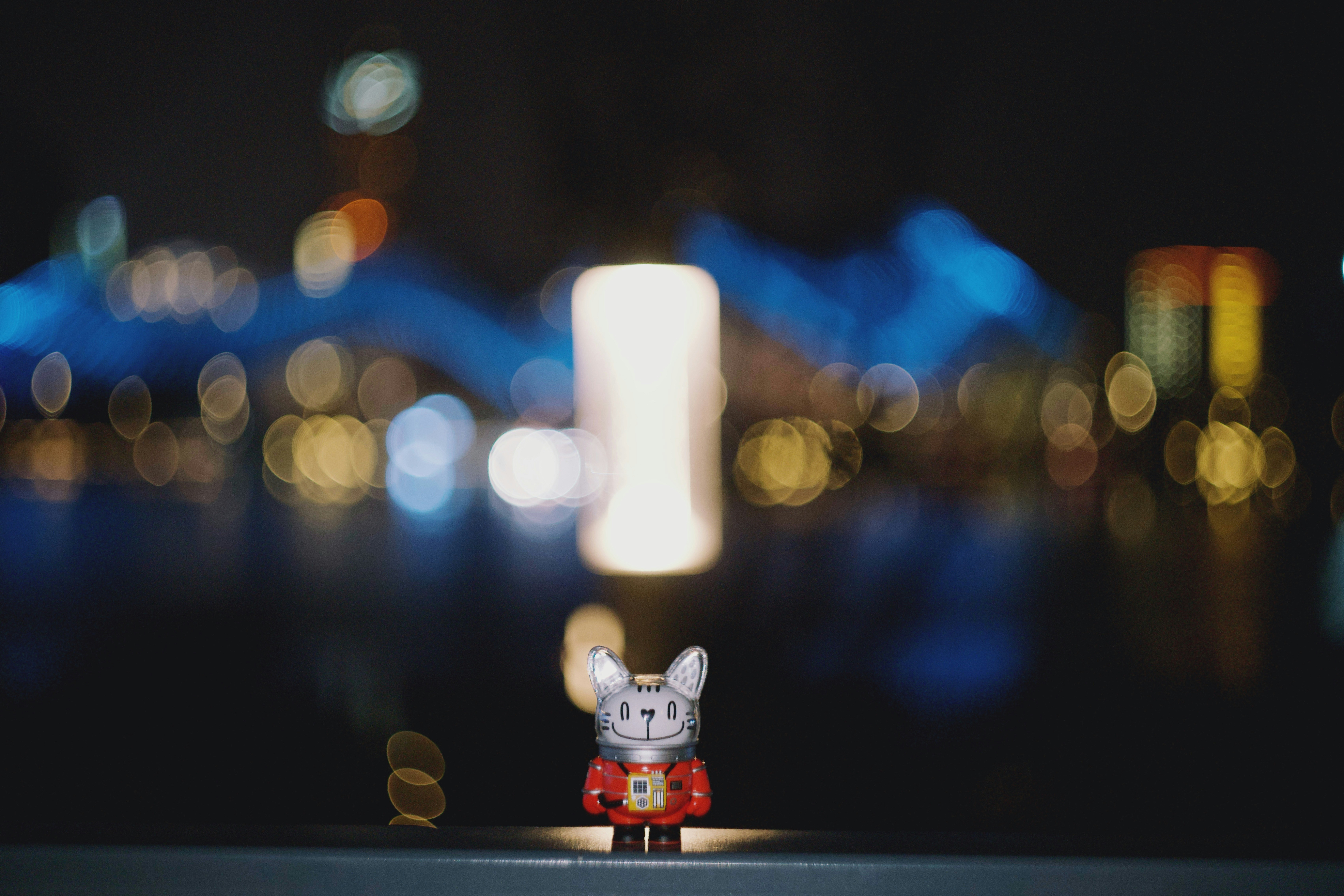 Ein kleines Spielzeug sitzt vor einer verschwommenen Stadtlandschaft