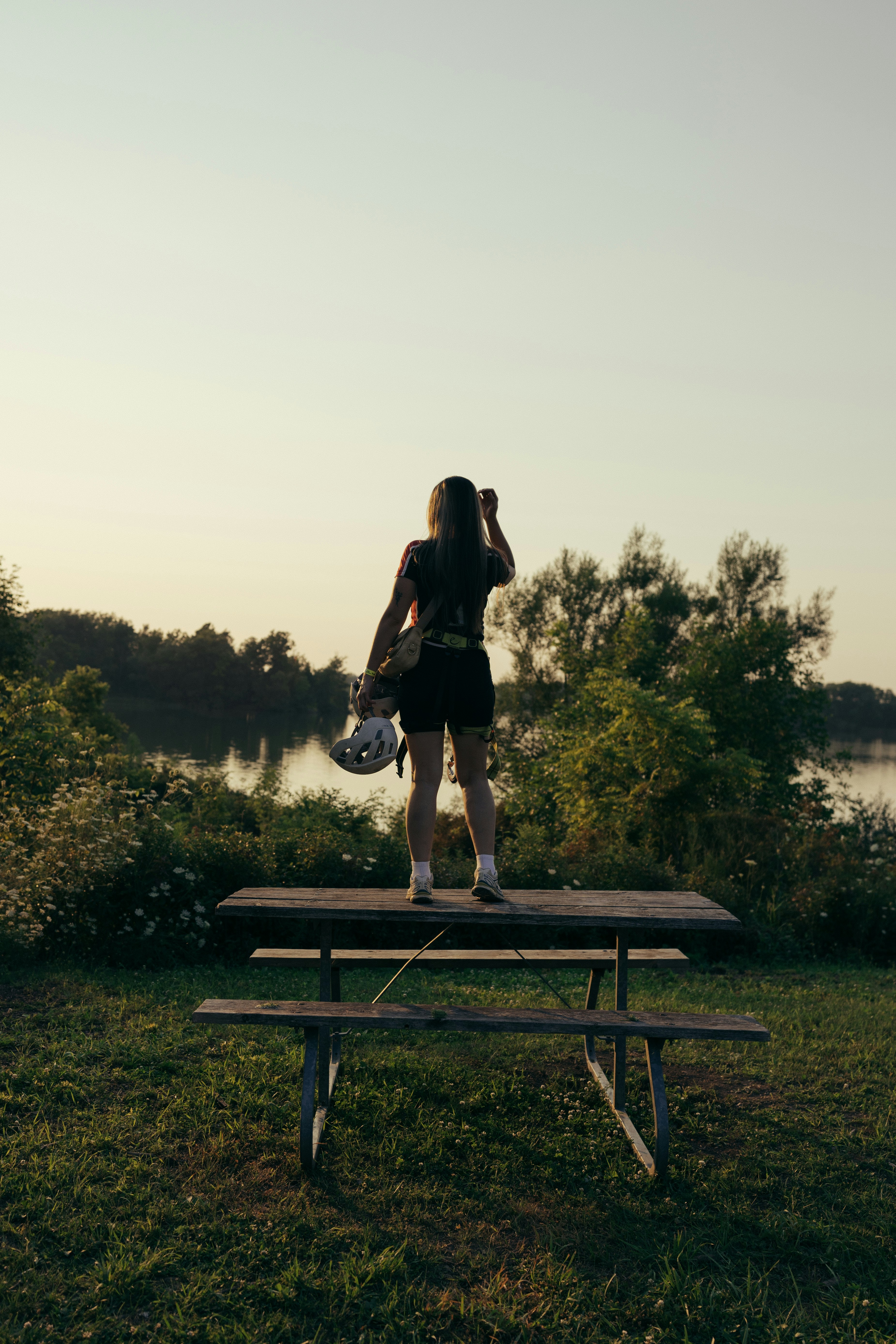 A woman standing on top of a picnic table