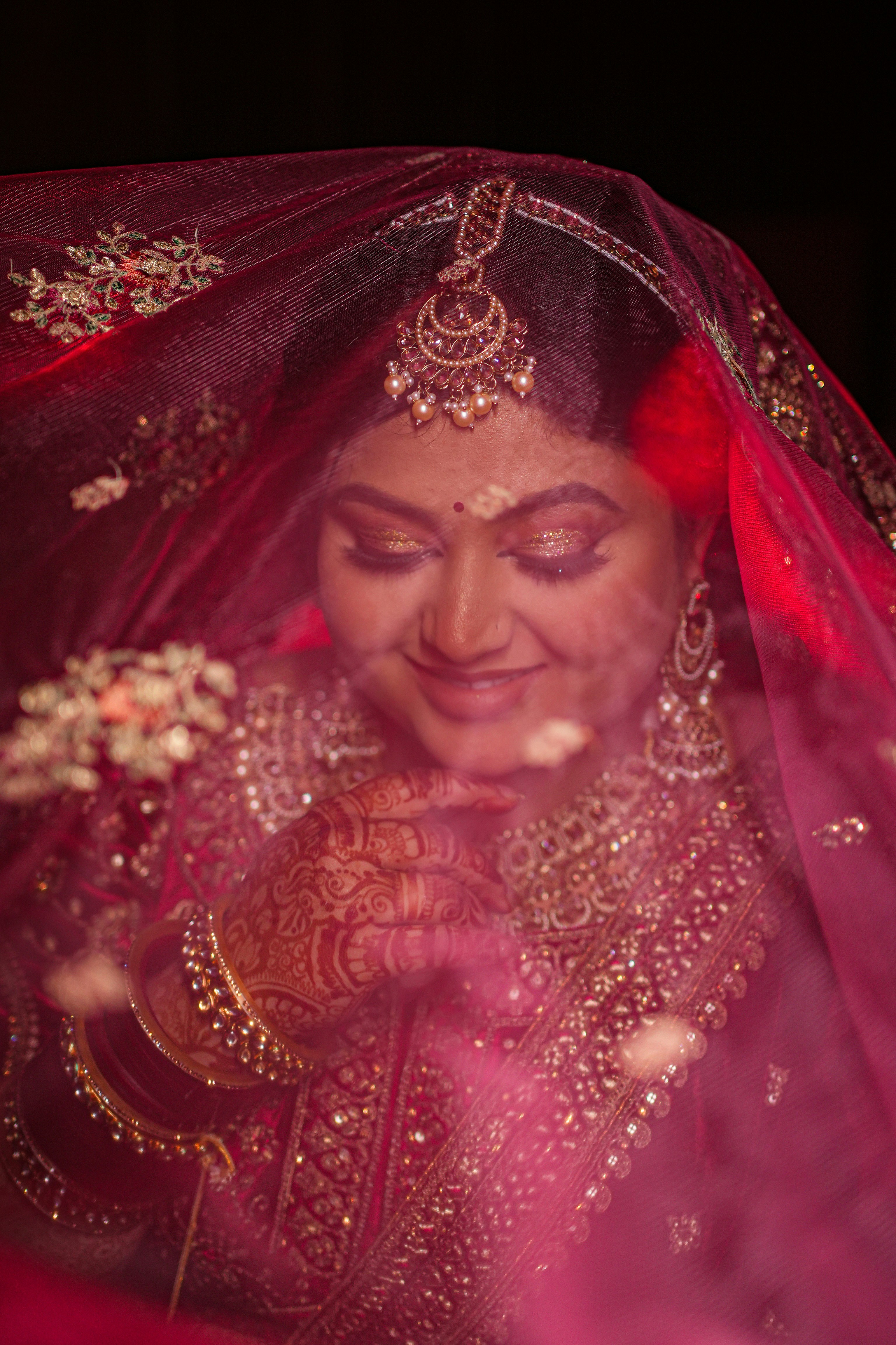 A woman in a red and gold wedding outfit