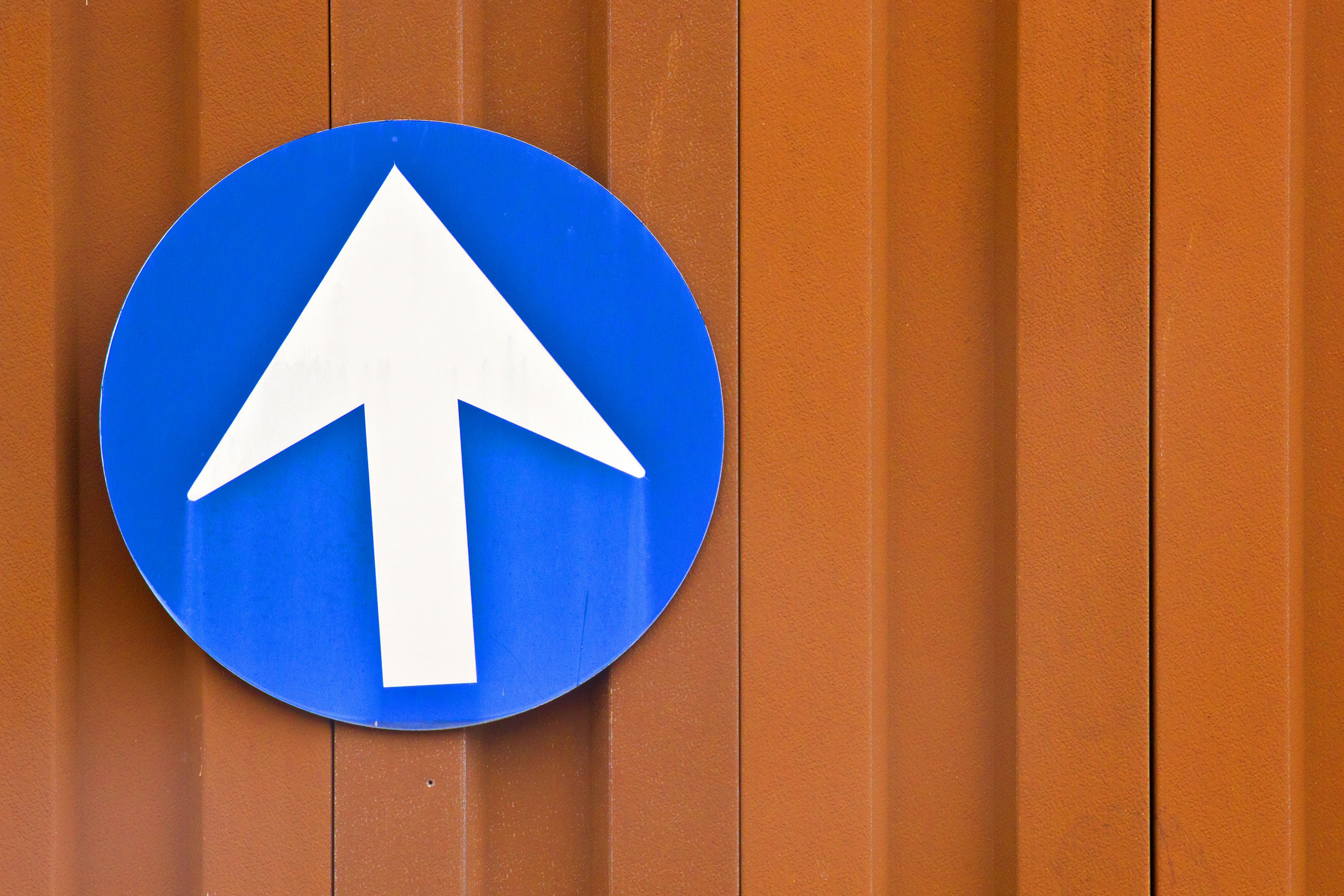 A blue sign with a white arrow on it