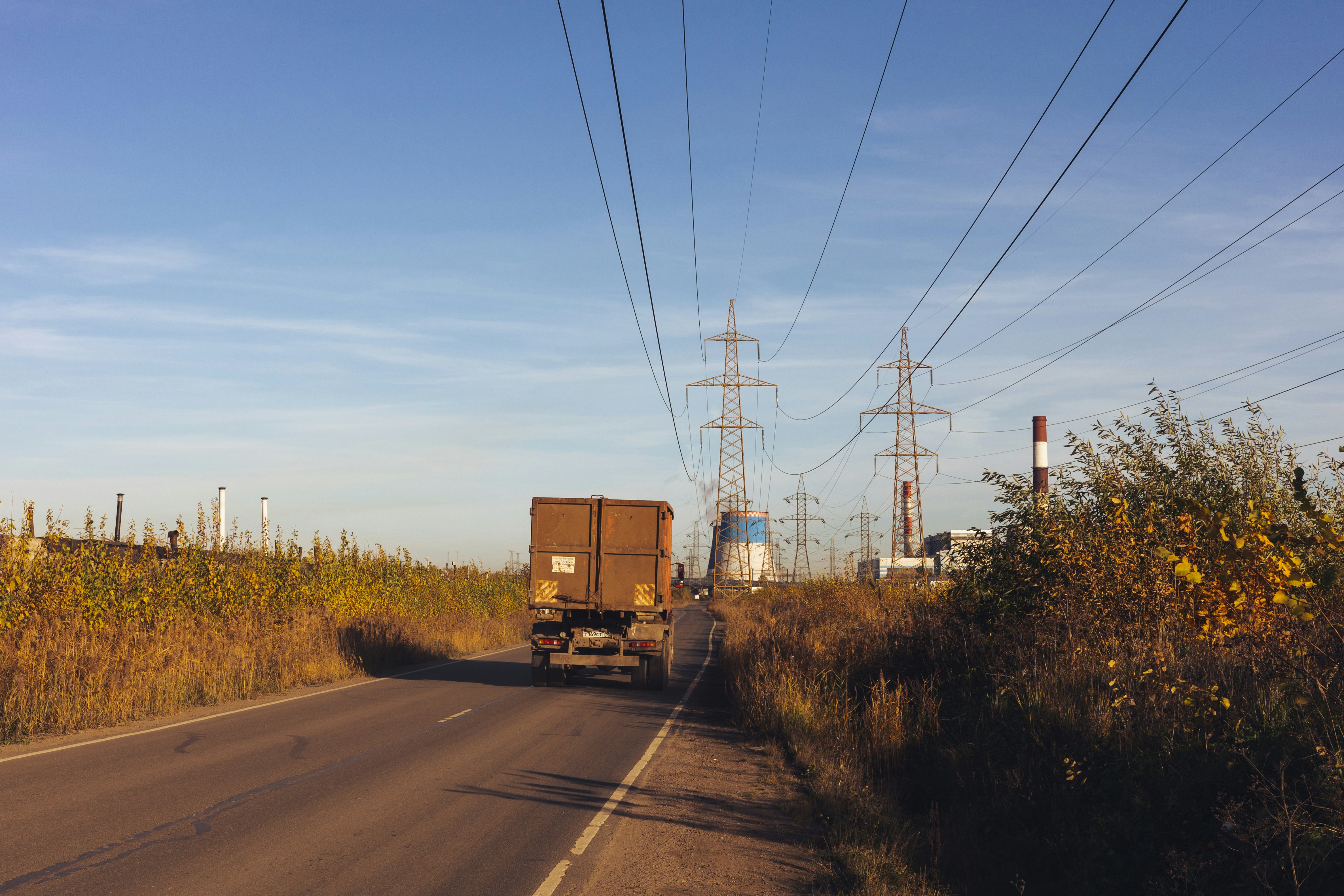A truck is driving down a rural road (Photo by Red Shuheart on Unsplash)