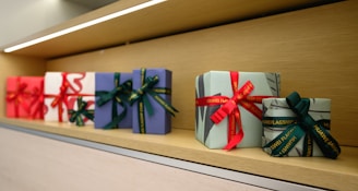 A row of wrapped presents sitting on top of a shelf