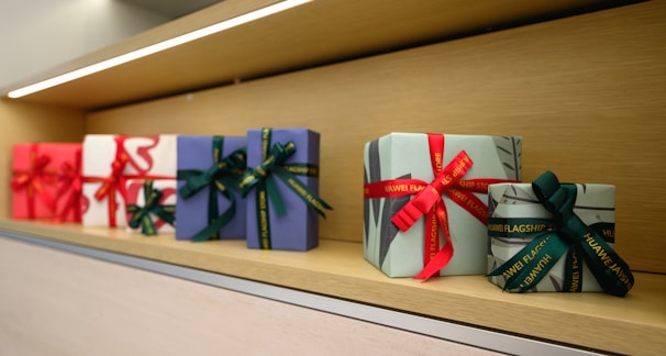 A row of wrapped presents sitting on top of a shelf