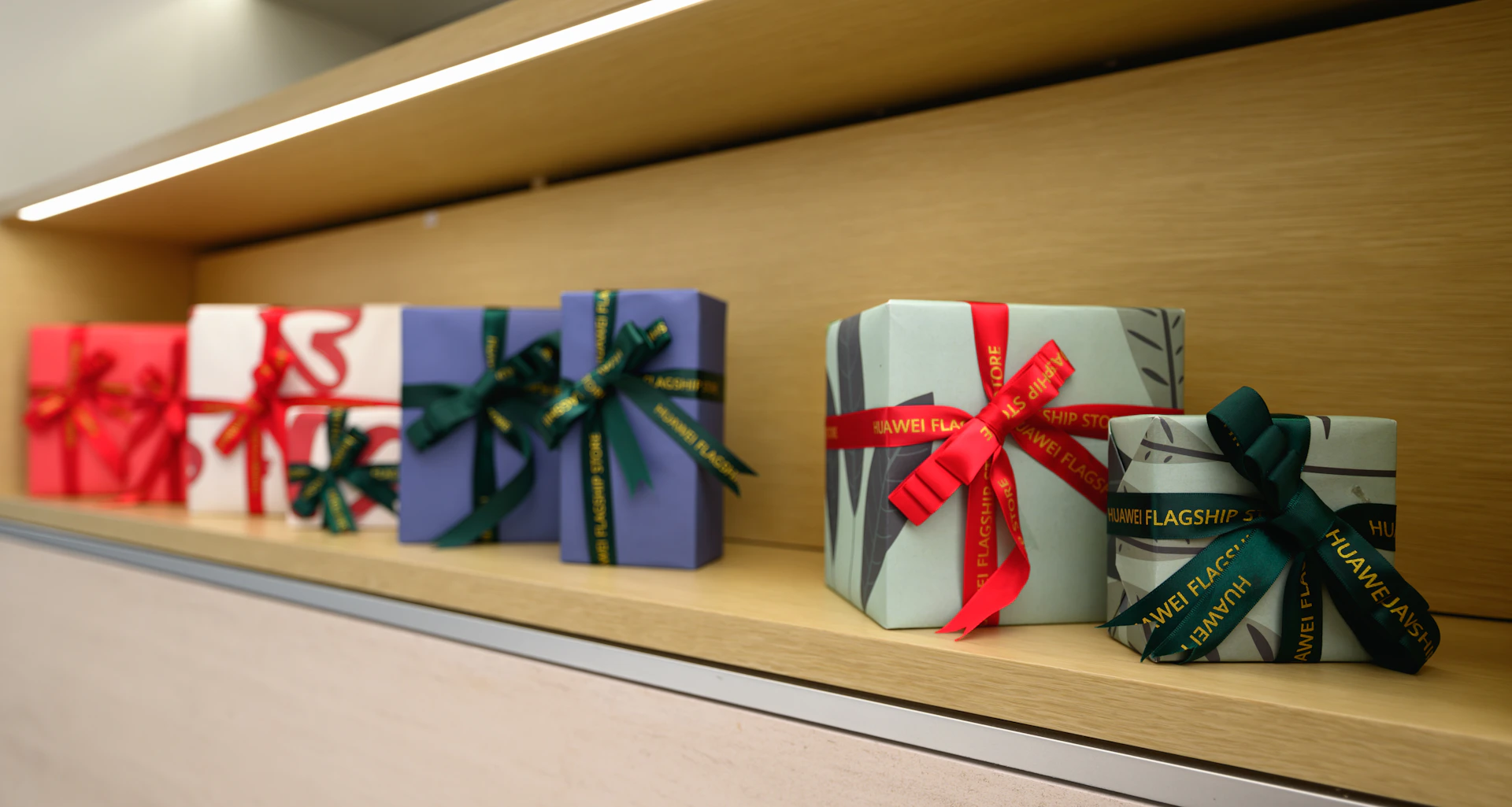 A row of wrapped presents sitting on top of a shelf