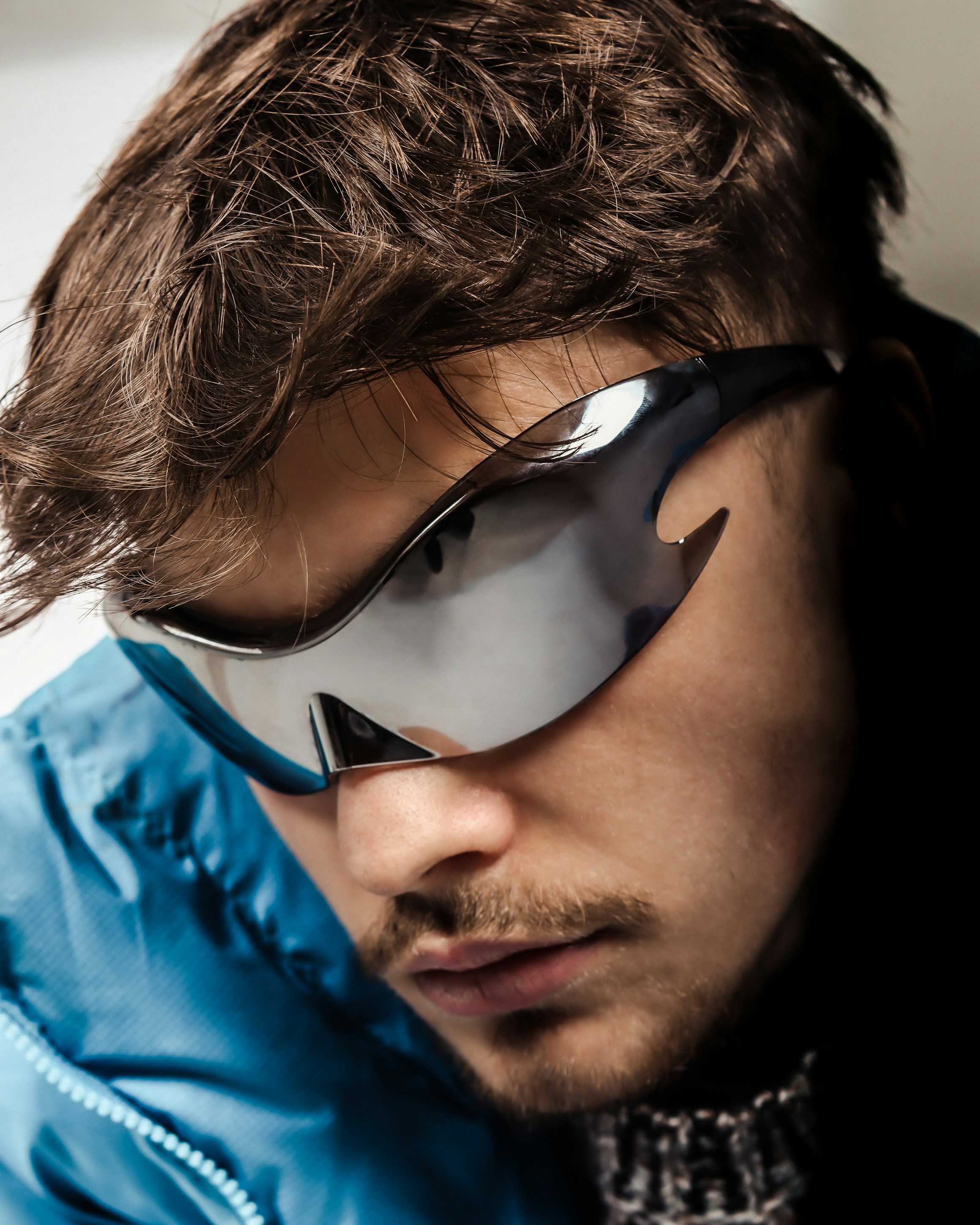 A man in a blue jacket wearing a pair of sunglasses