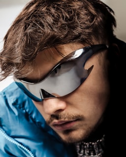 A man in a blue jacket wearing a pair of sunglasses