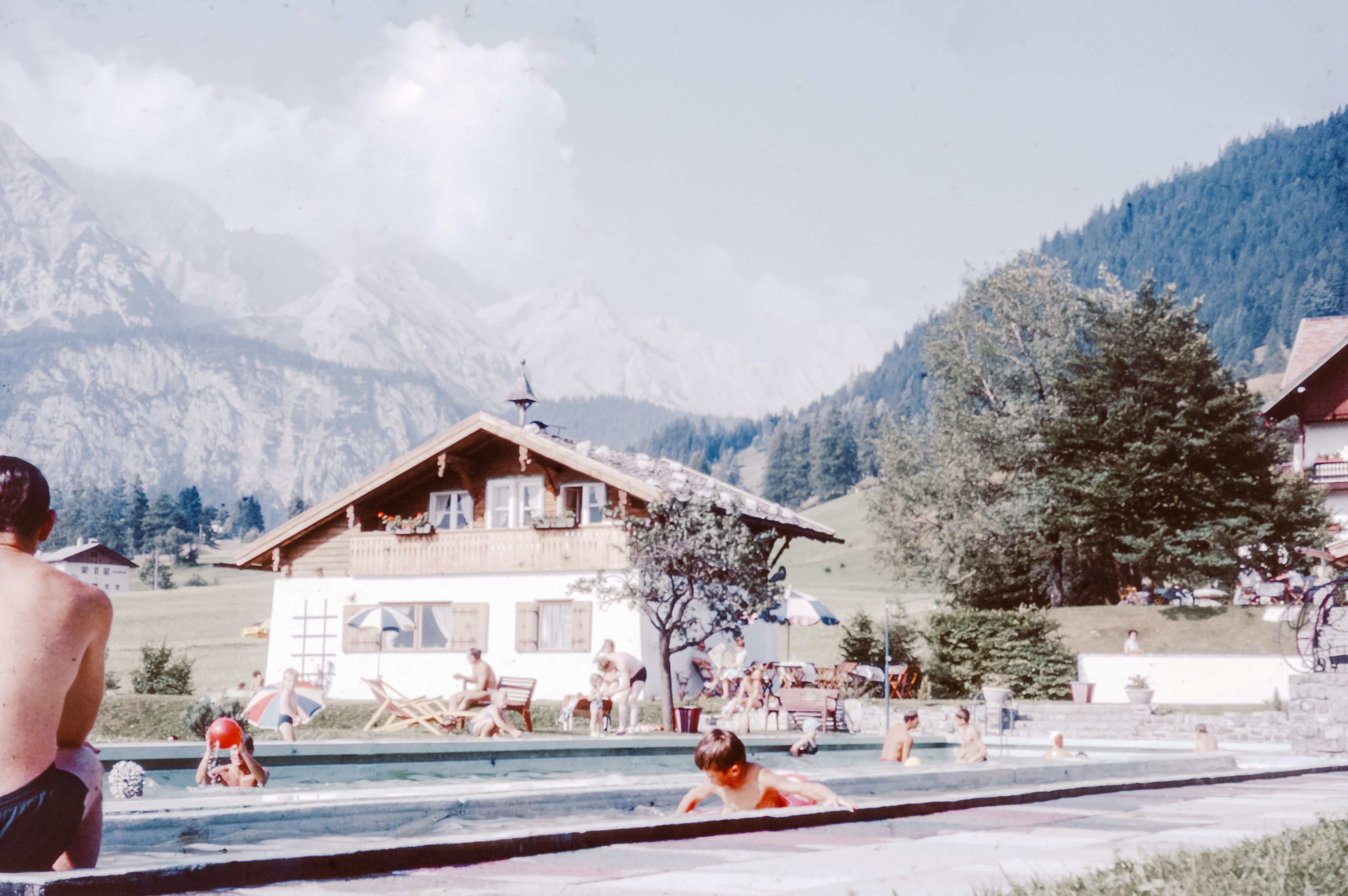 A group of people swimming in a pool next to a mountain