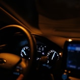 The dashboard of a car with a cell phone in it