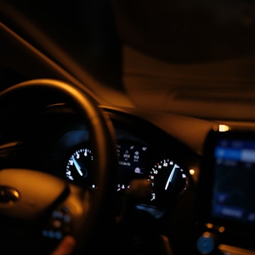 The dashboard of a car with a cell phone in it