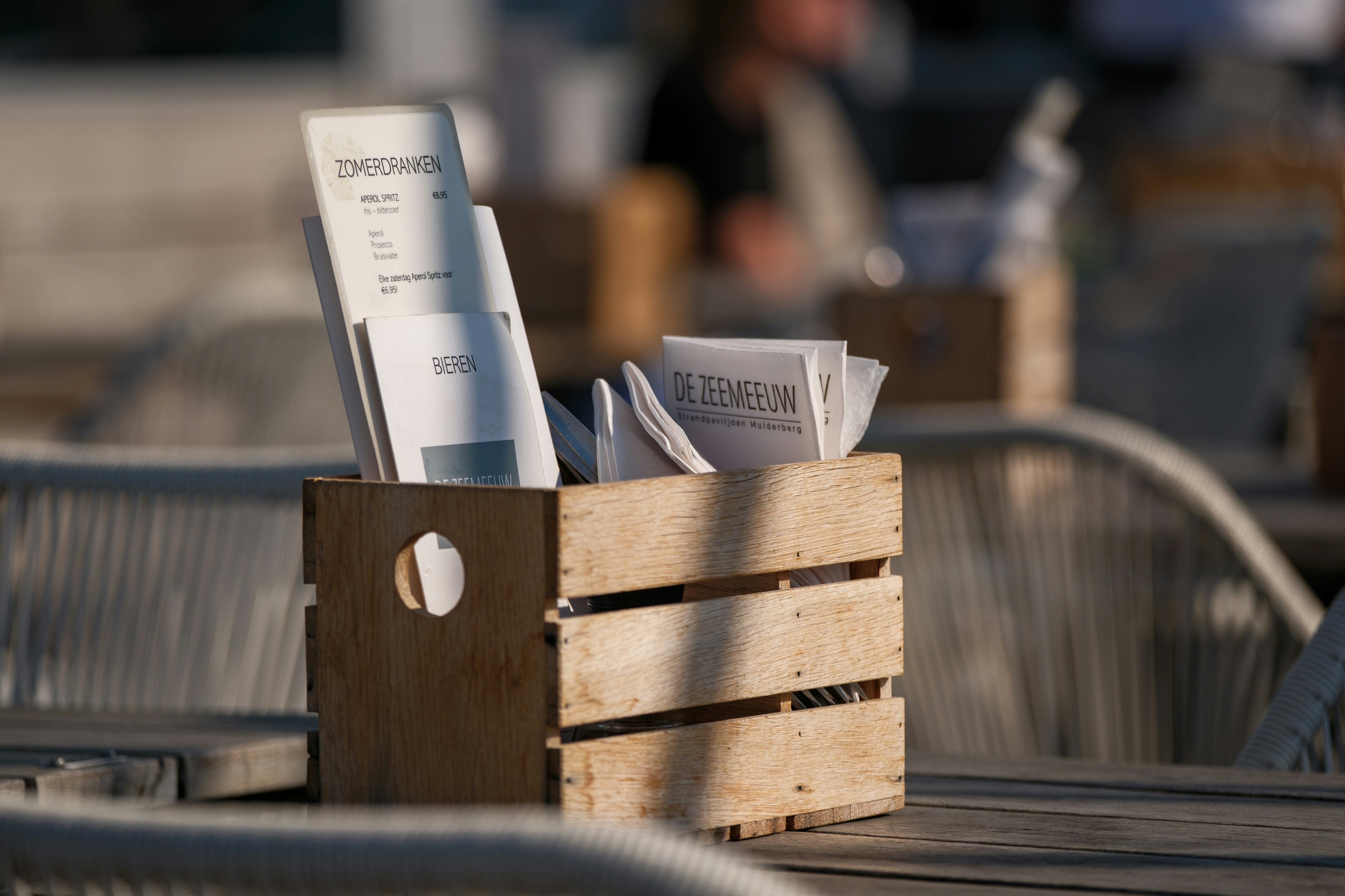 A wooden crate filled with papers sitting on top of a wooden table