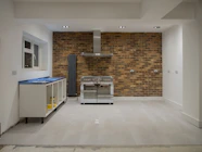 A room with a brick wall and a stove