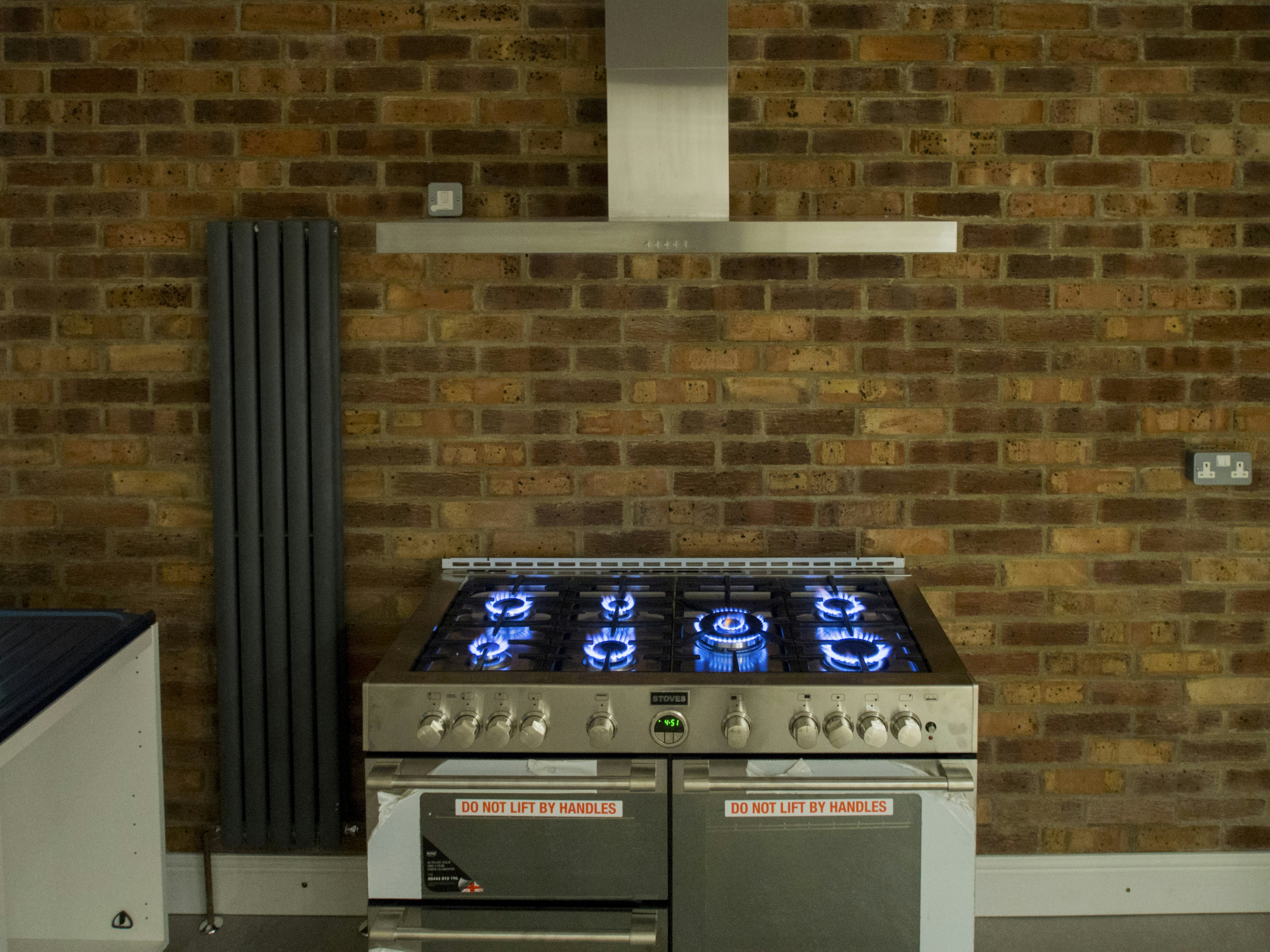 A stove top oven sitting in front of a brick wall
