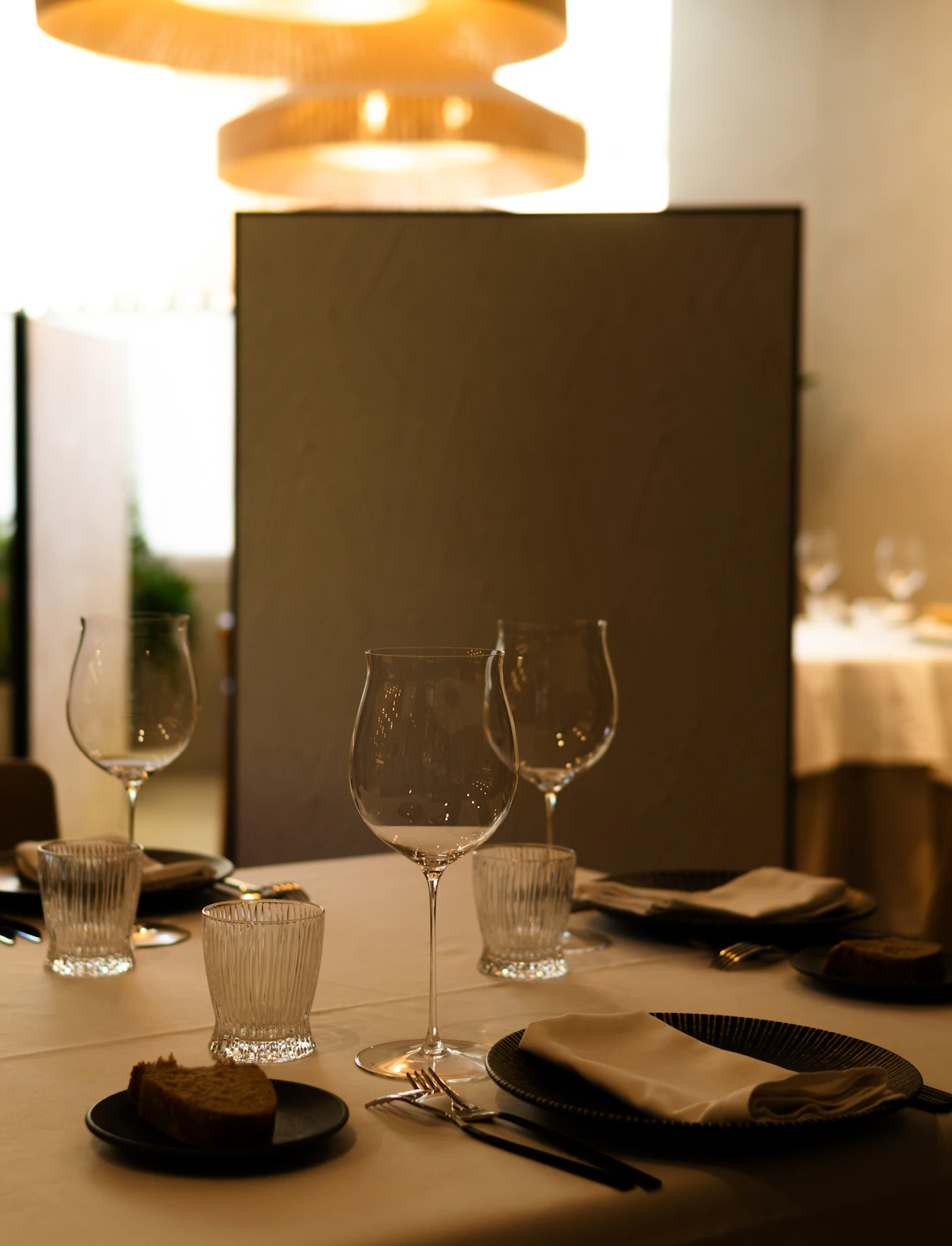 Real dining table set with clear stemmed glasses and place settings