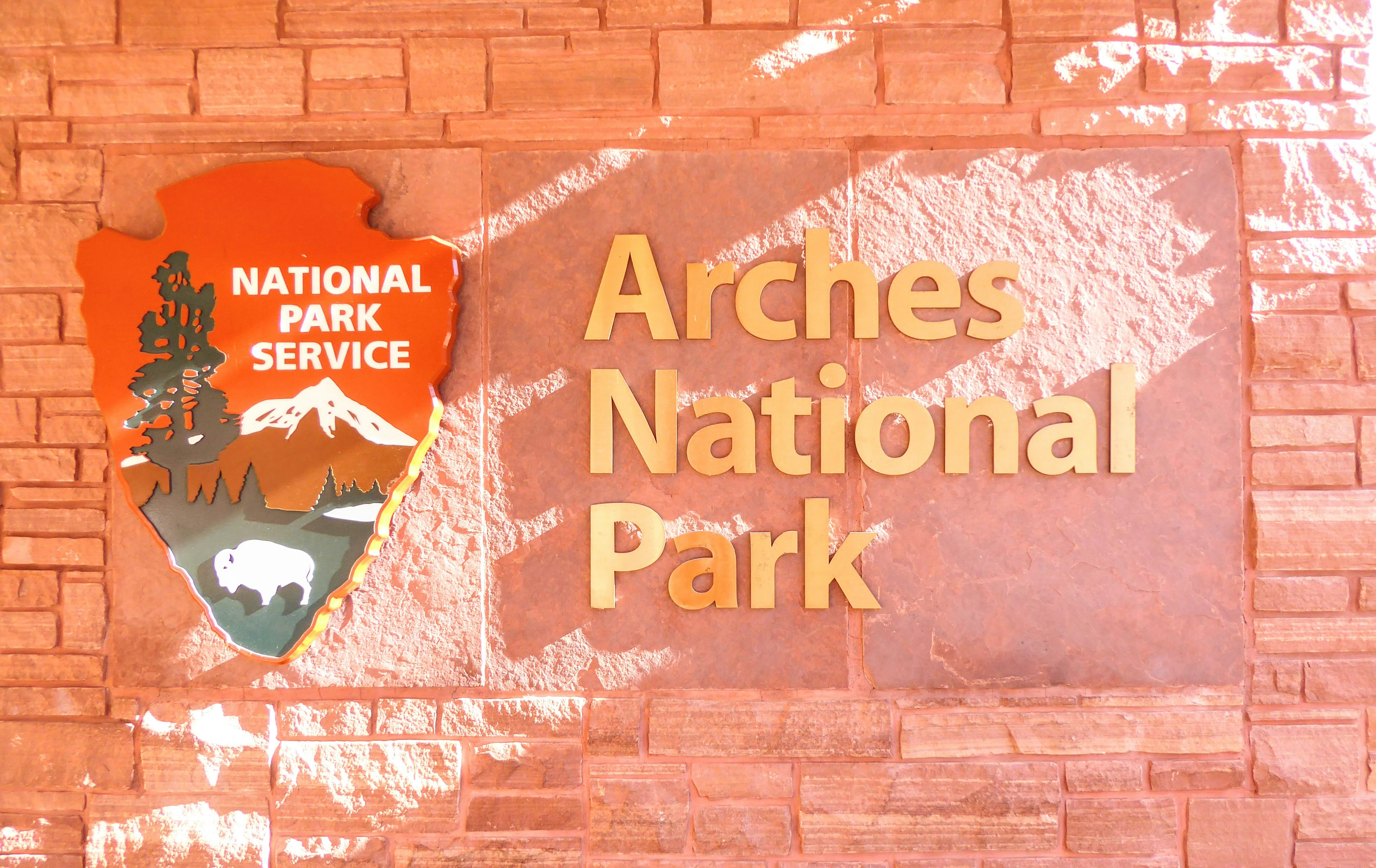 A sign on a brick wall that says arches national park