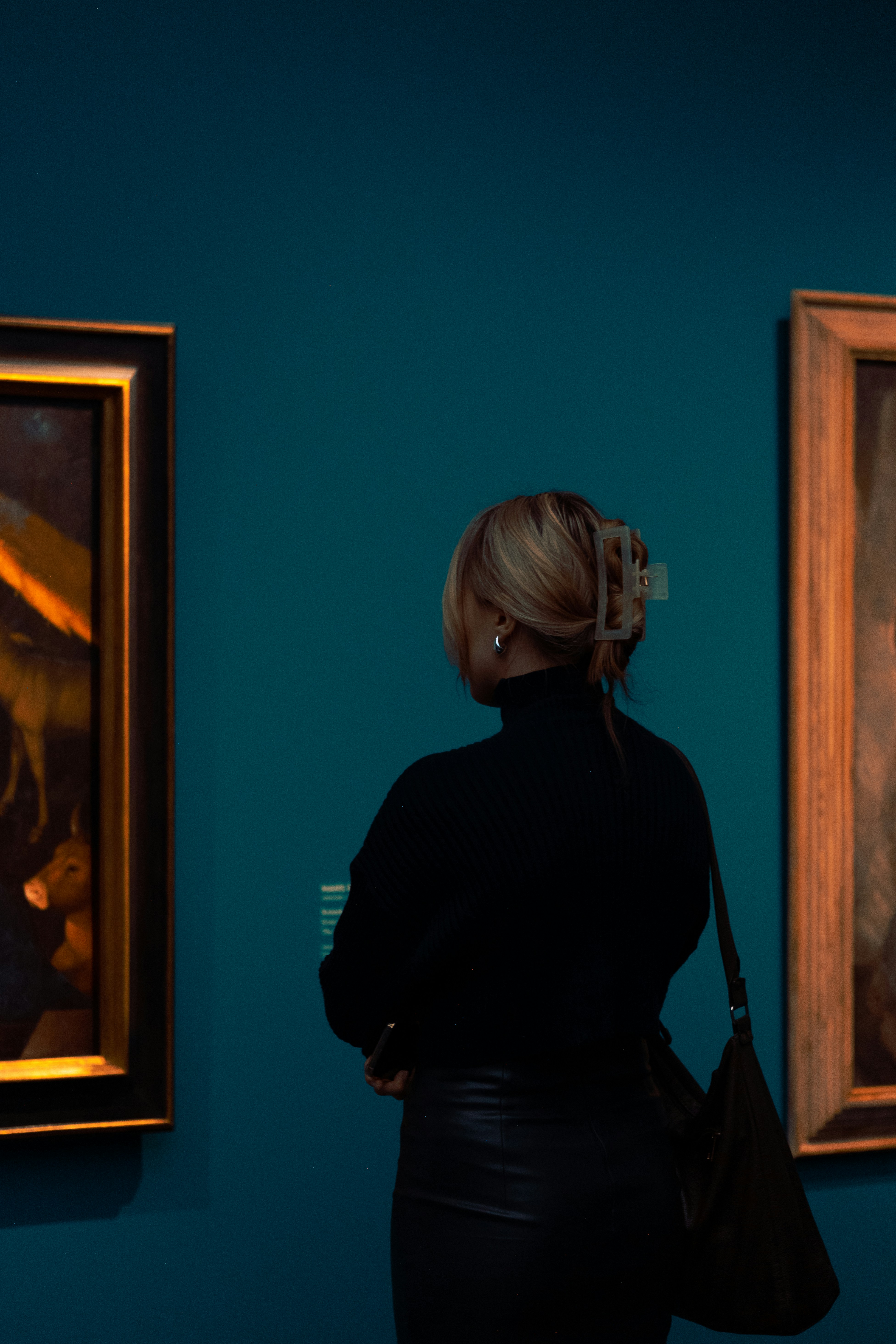A woman looking at paintings in a museum